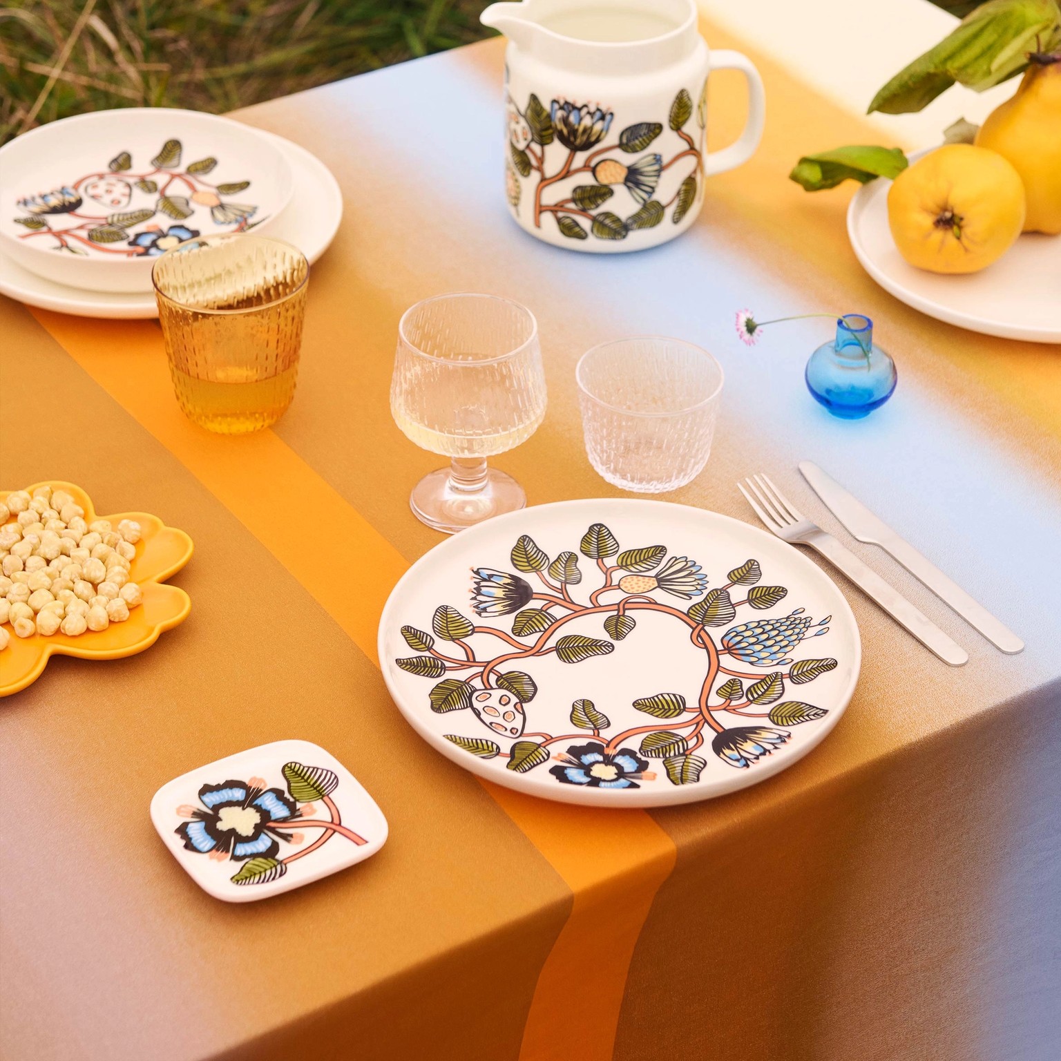 Tablesetting with Syksy glassware and plates and jar in Tiara pattern.