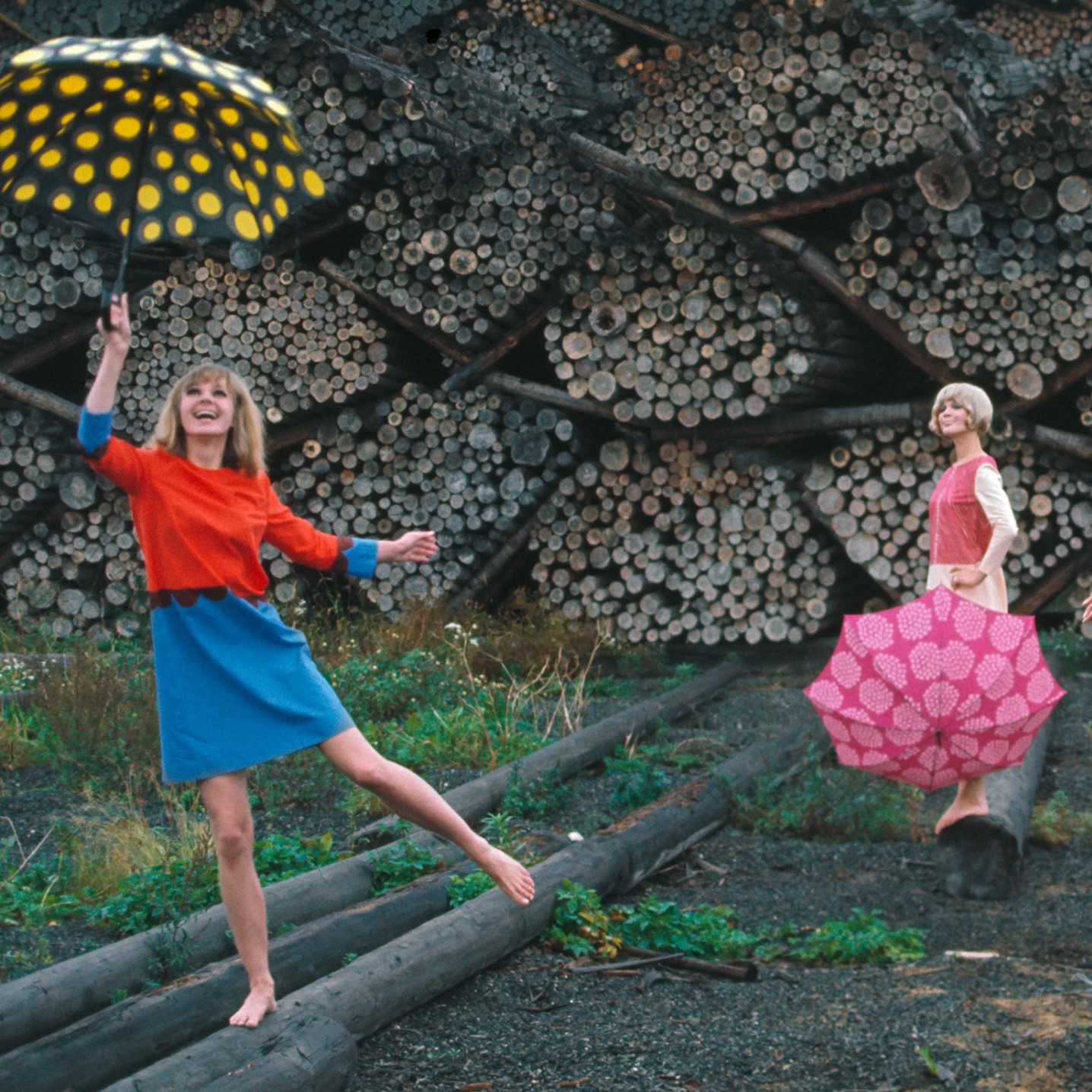 Foto von Tony Vaccaro von zwei Models, die Marimekko-Kleidung tragen und Regenschirme halten.