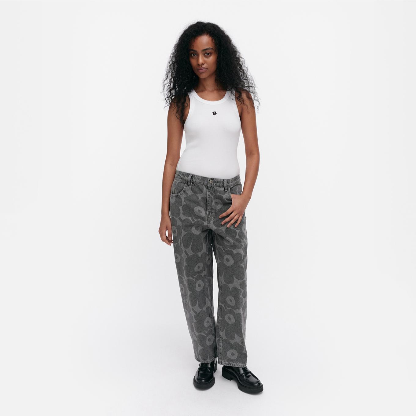 Model wearing Maridenim Barrel jeans in grey Unikko pattern.