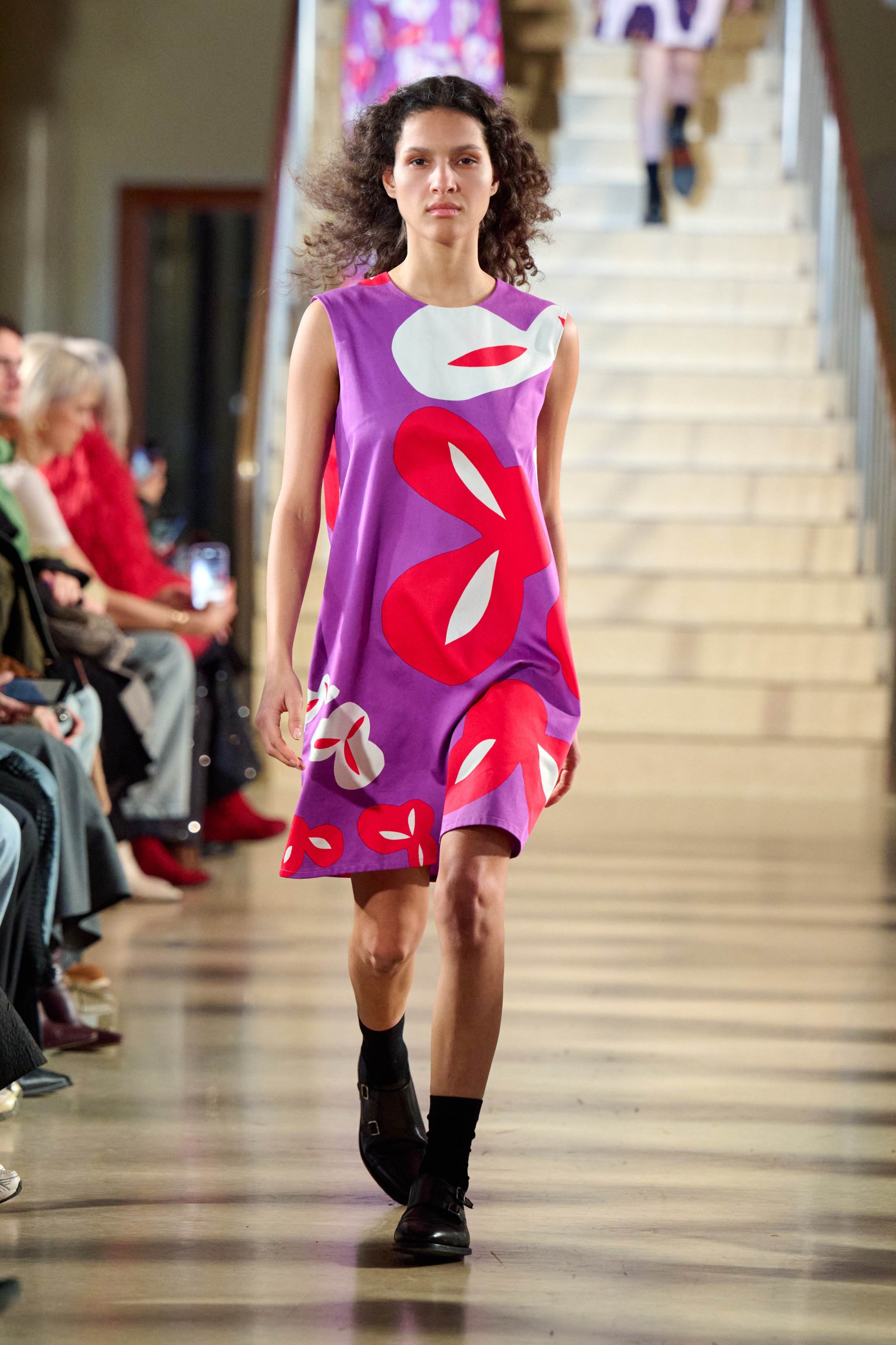 A model walks in the Marimekko fashion show wearing a light purple-pink Marimini dress
