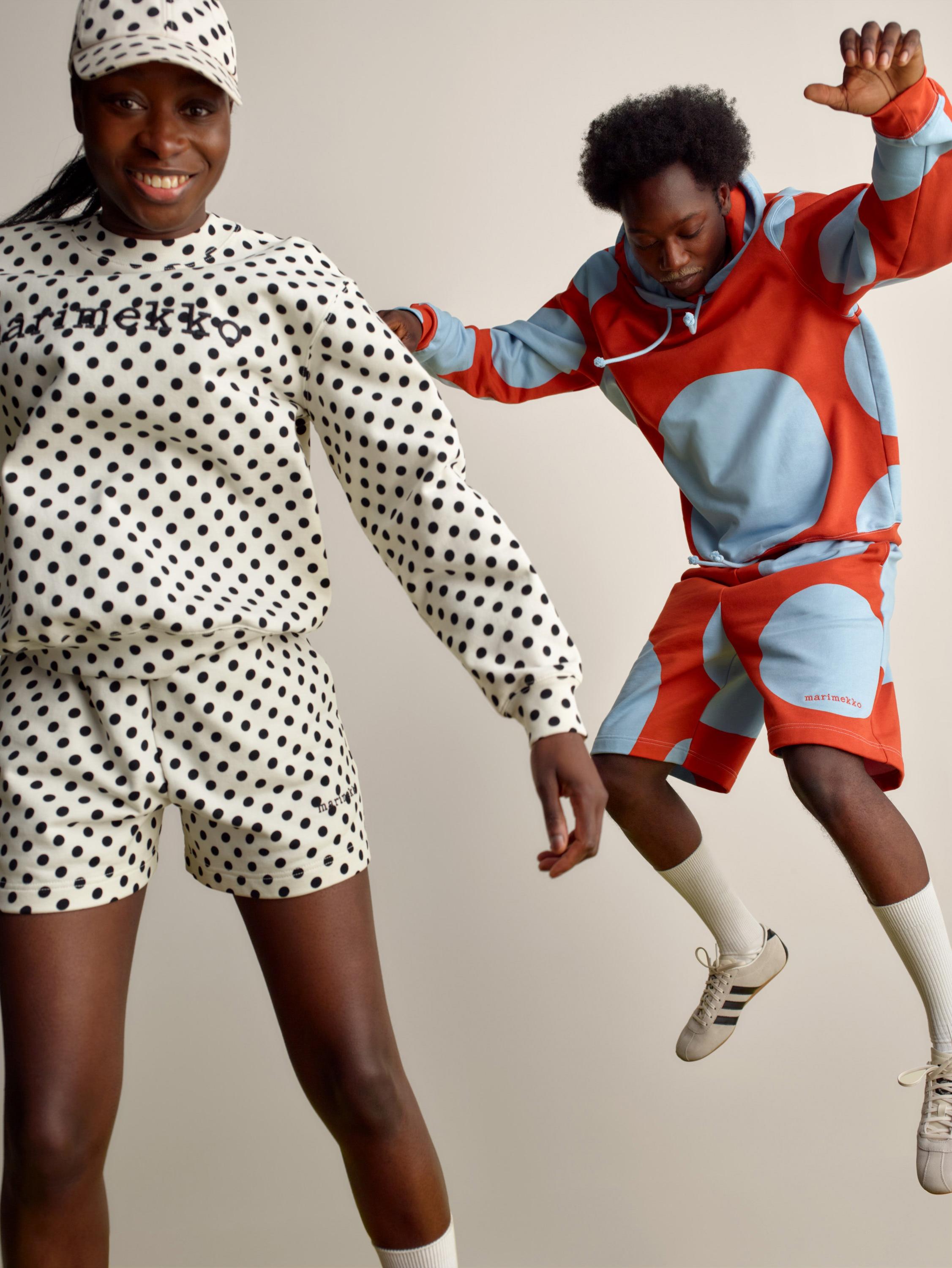 Two happy models jumping and wearing Marimekko Kioski sets in Pallo and Klaava prints.