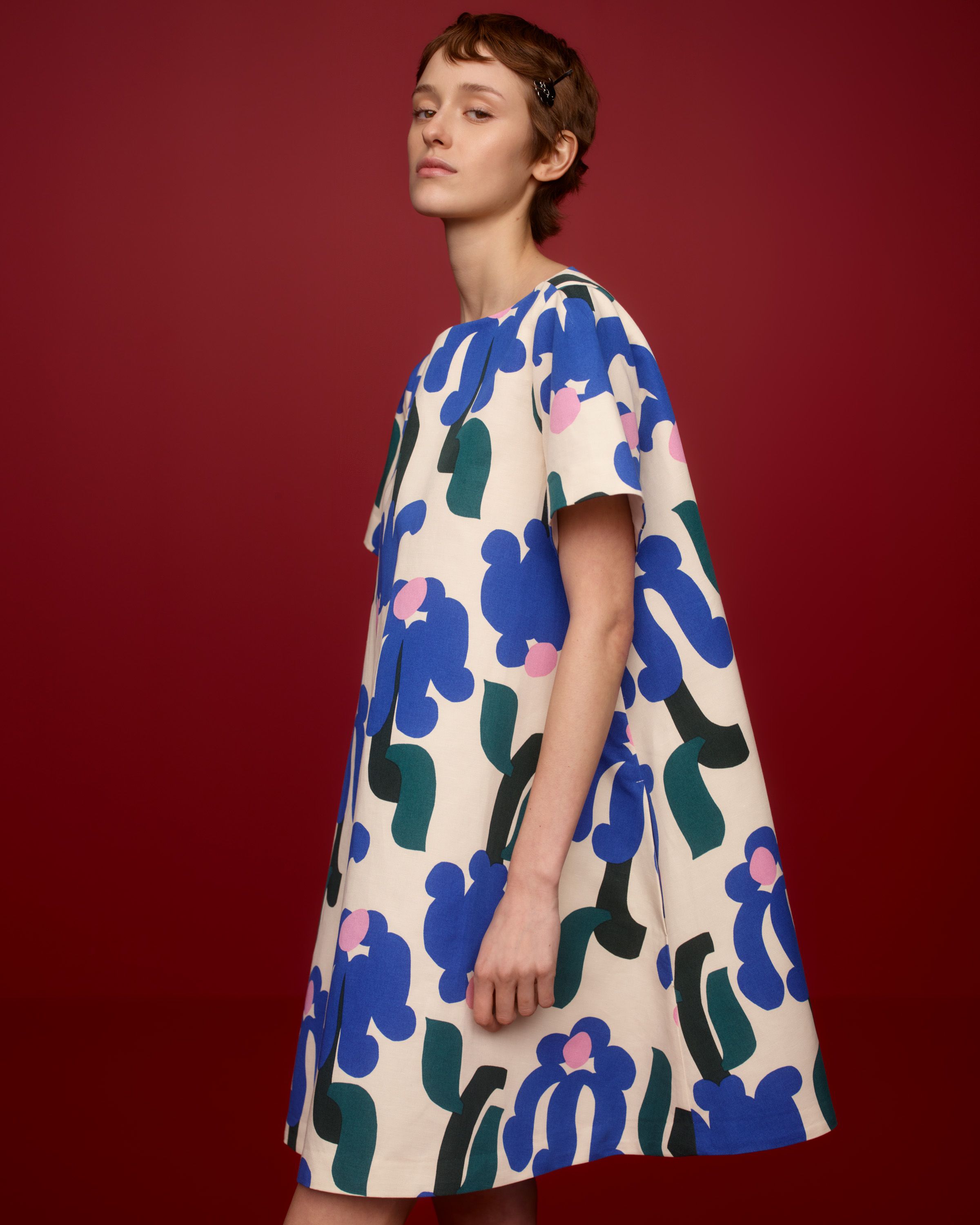Model wearing a mini lenght t-shirt dress in Kukkahattu print.