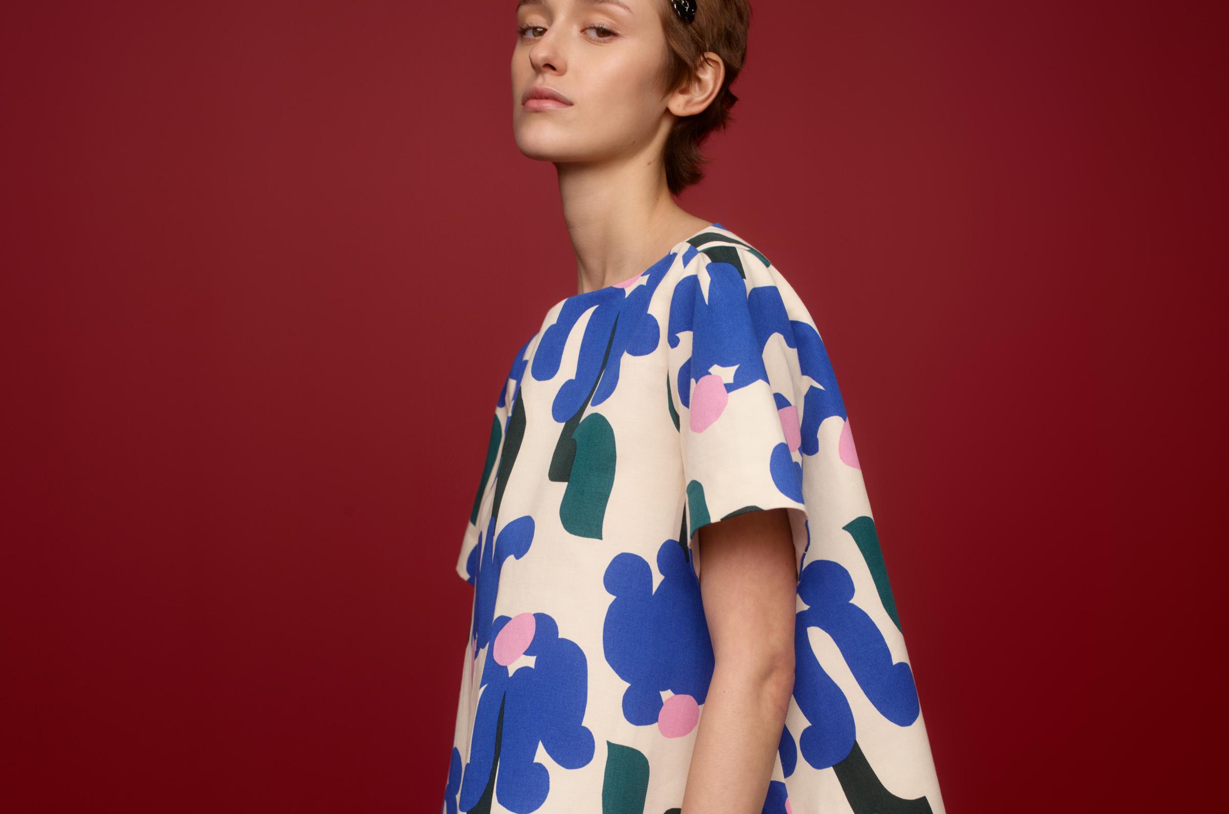 Model wearing a mini lenght t-shirt dress in Kukkahattu print.