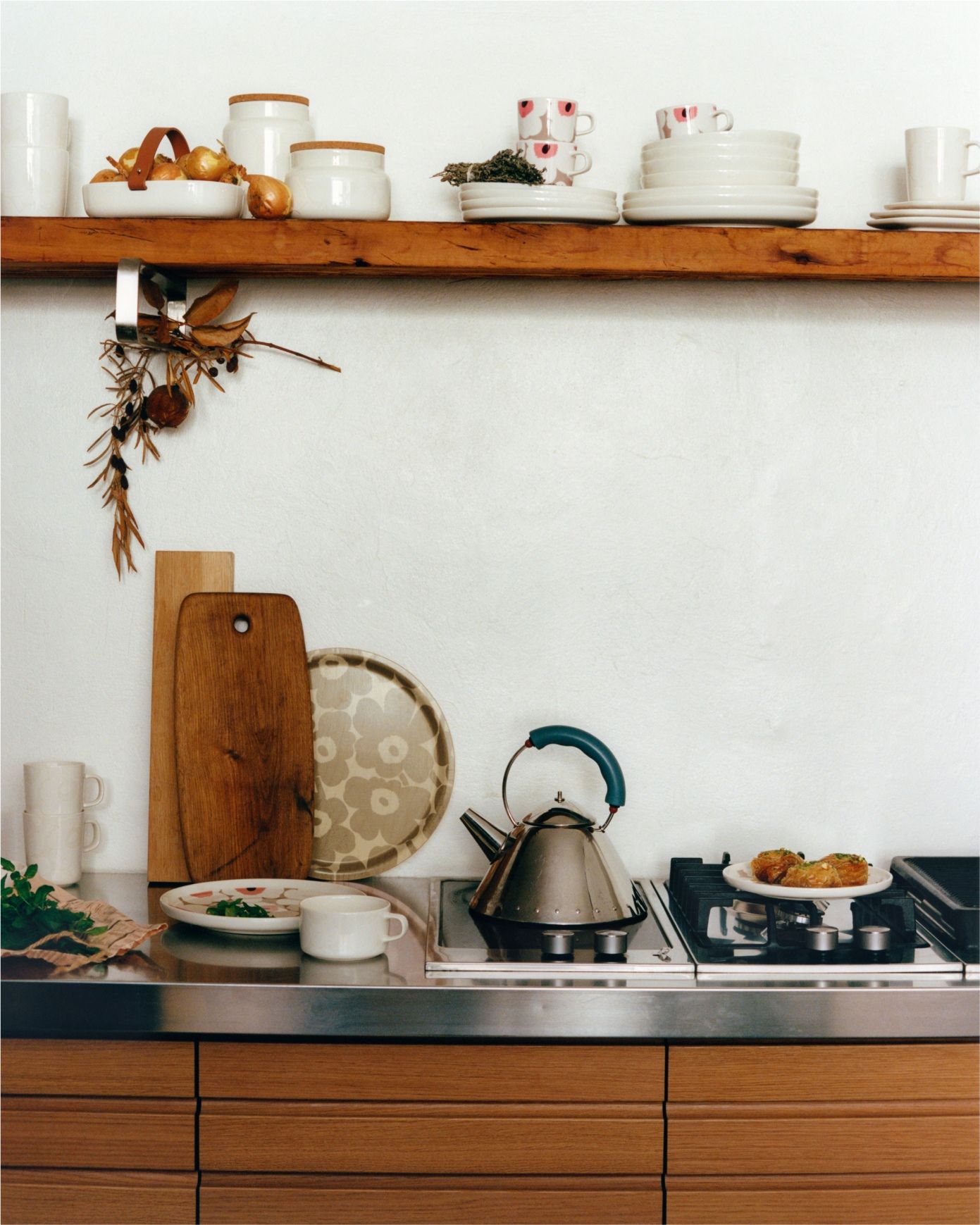 Oiva-astioita aseteltuna keittiöhyllylle.