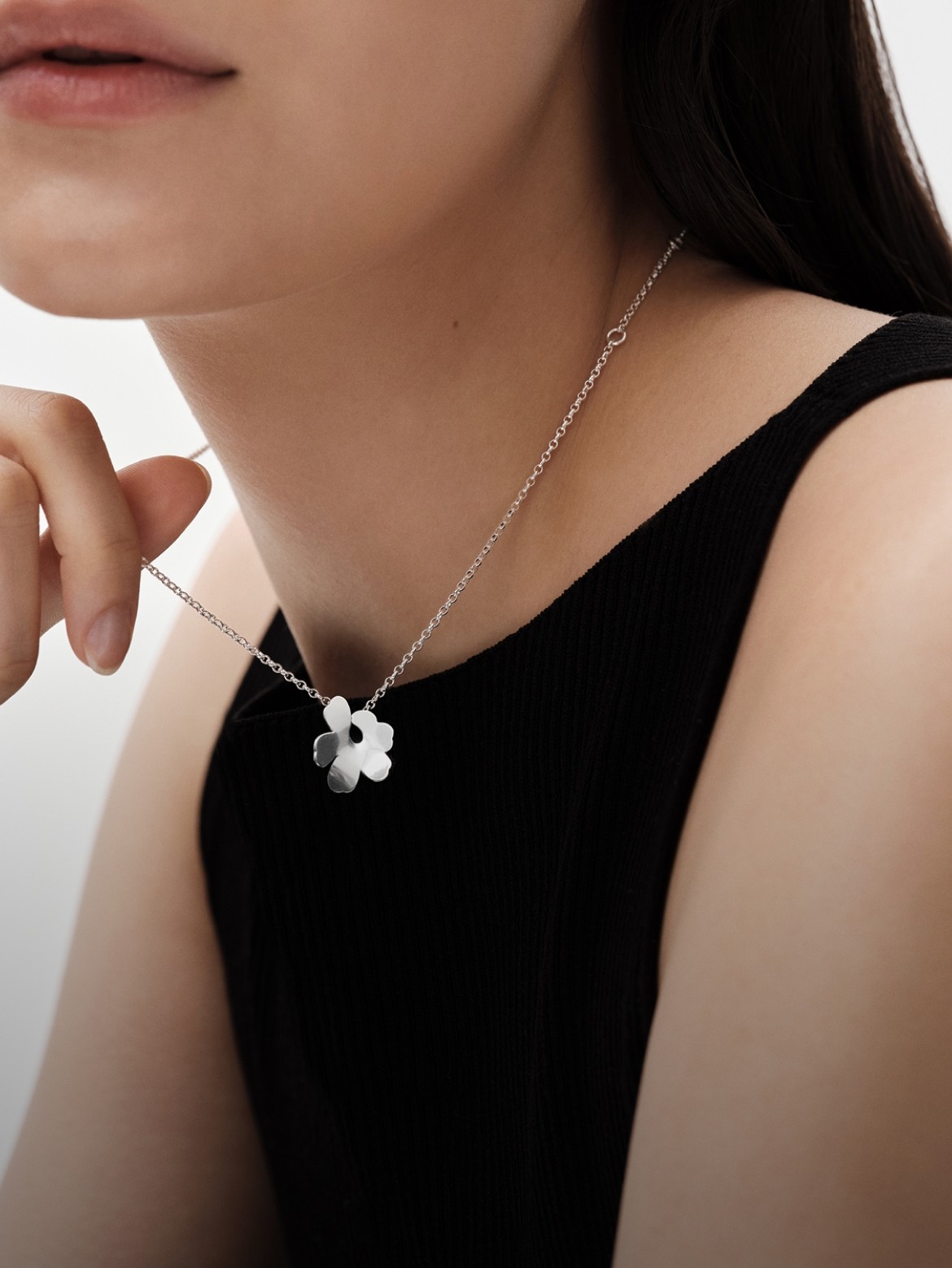 Silver Unikko necklace on the model's neck. 