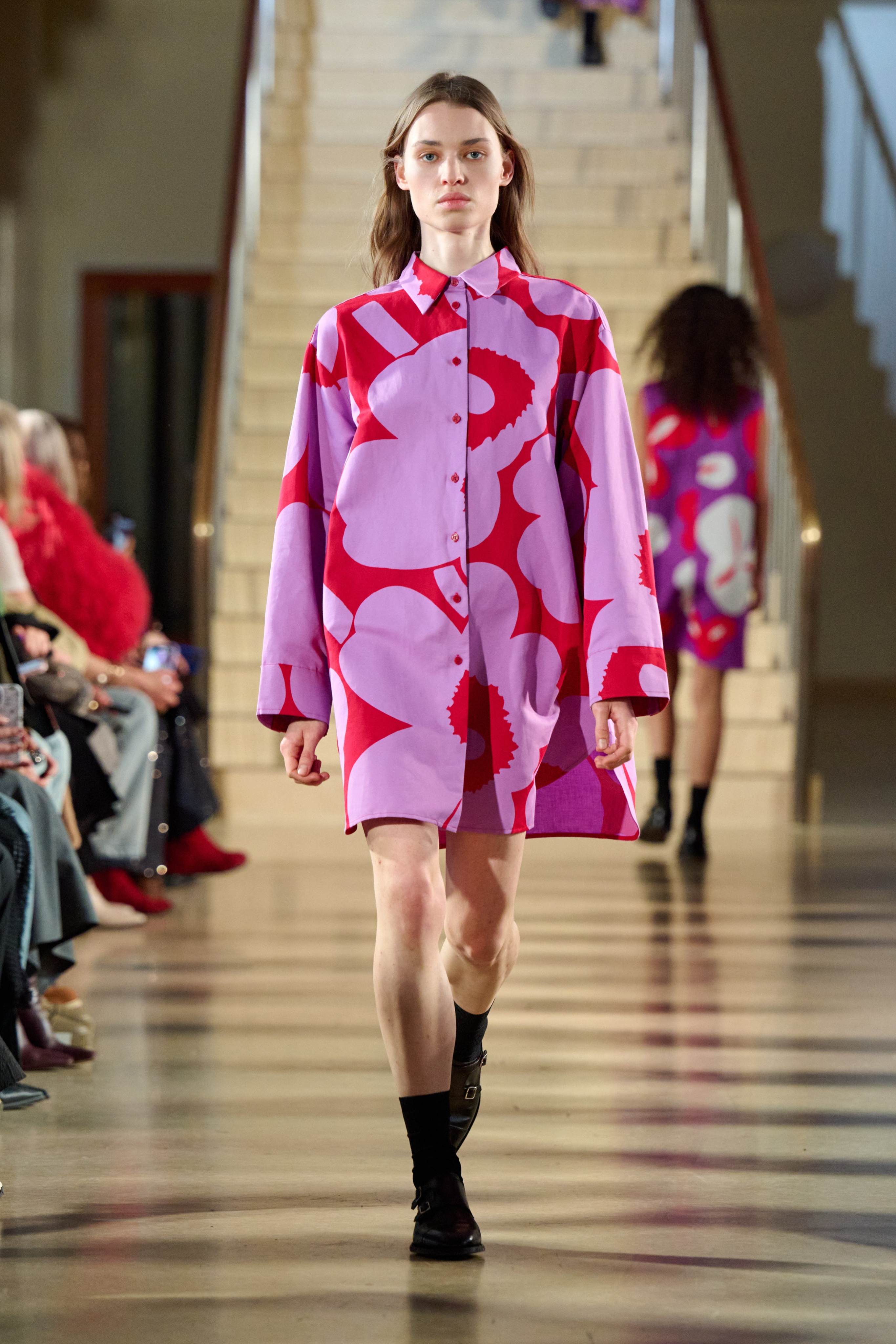 Model wearing a red/lilac shirtdress in Unikko print.