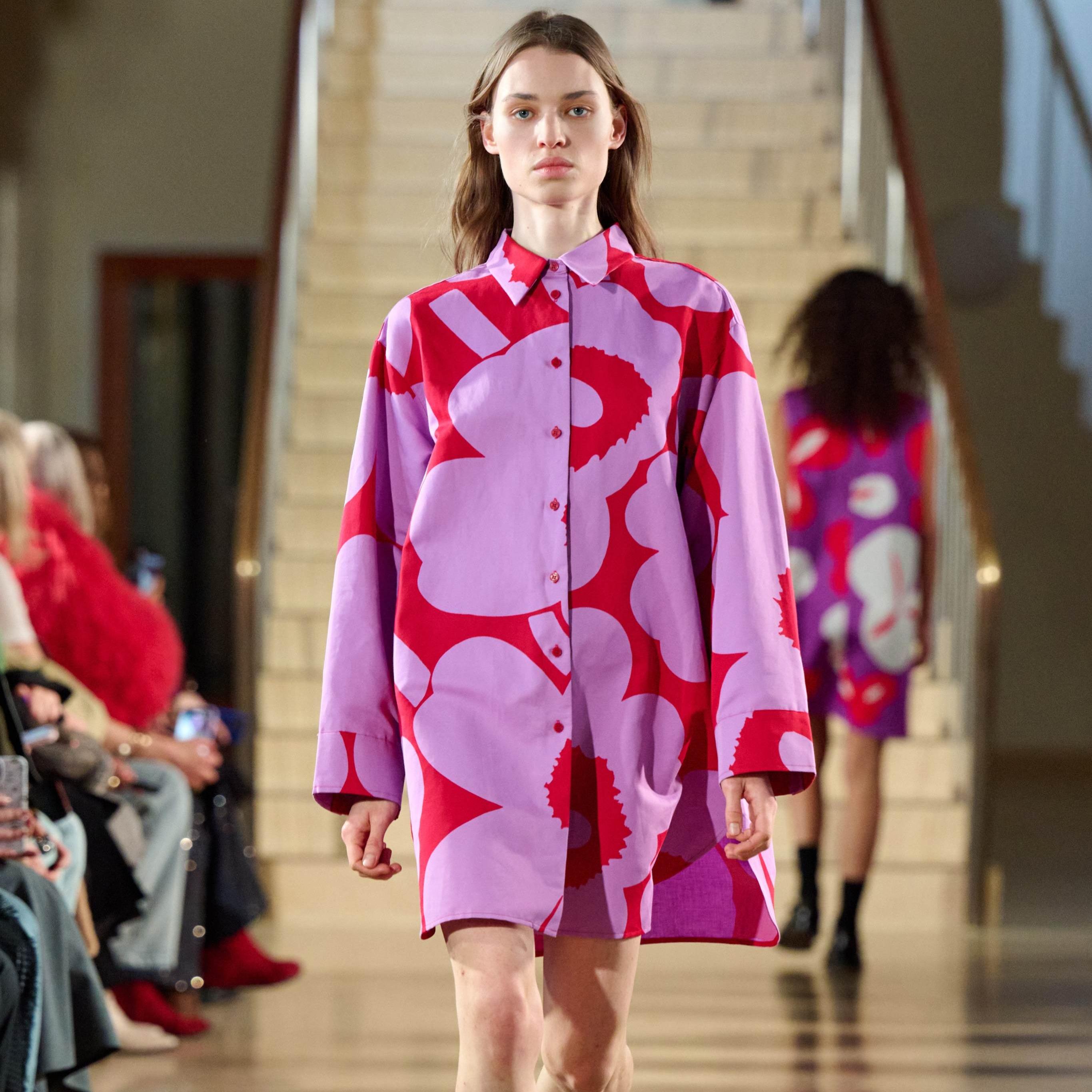 Model wearing a red/lilac shirtdress in Unikko print.