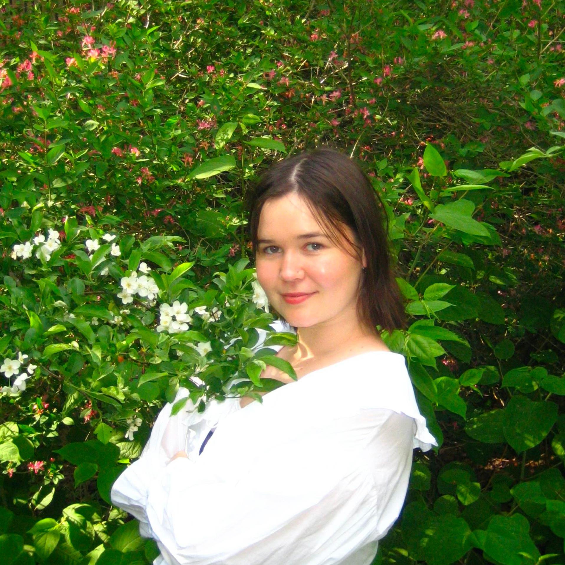 Visual artist Emma Thomas in front of a summer flower display