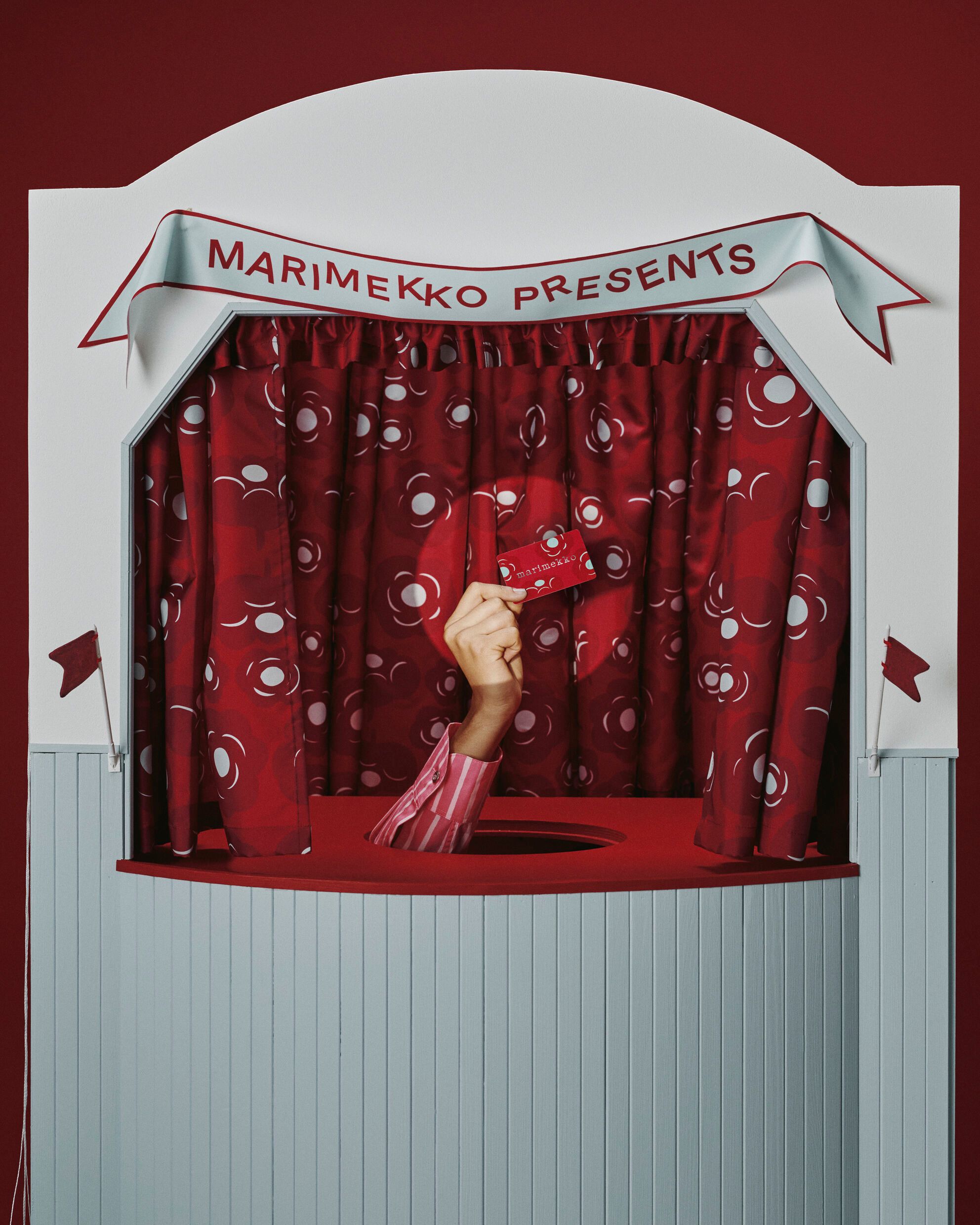 Hand holding up a Marimekko gift card.