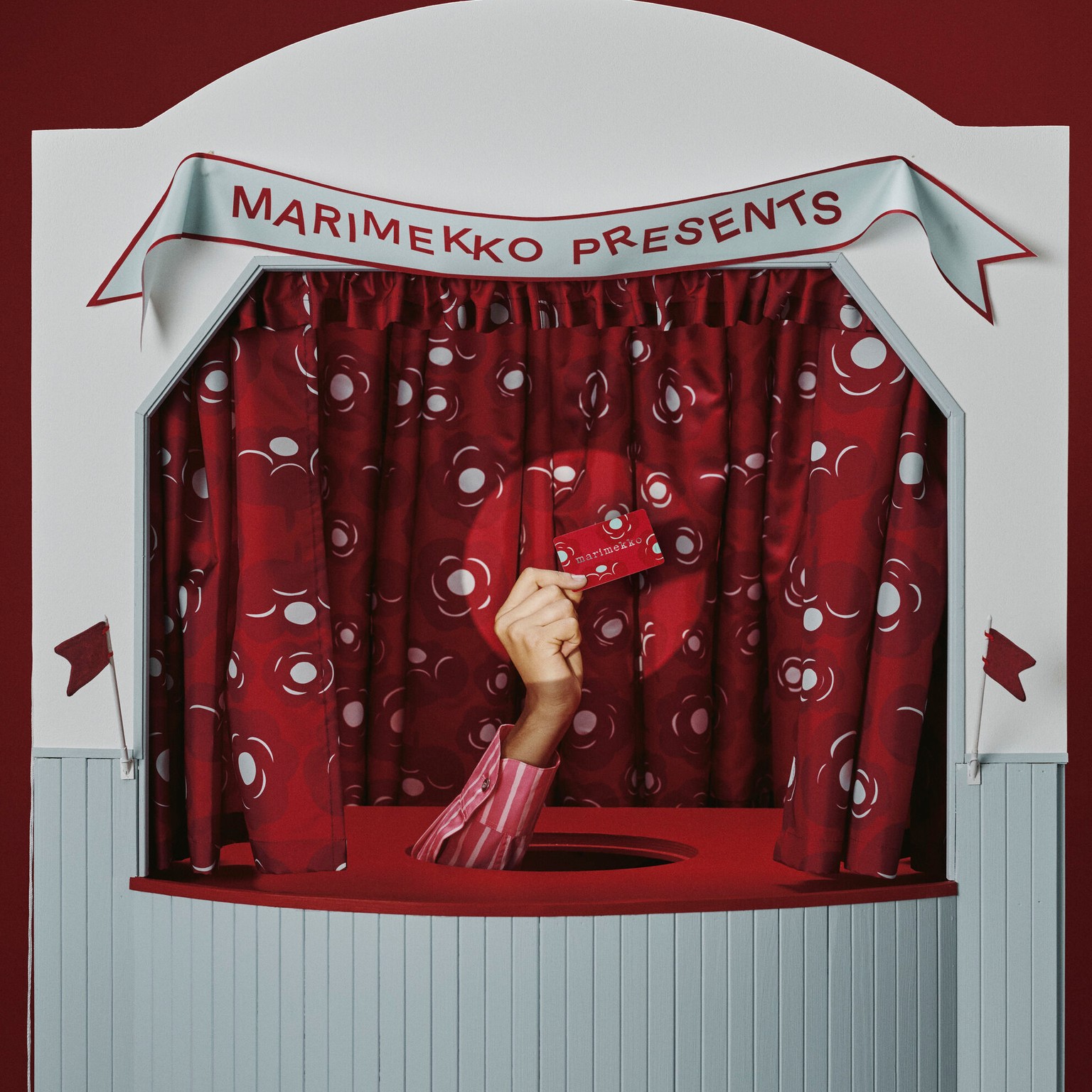 Hand holding up a Marimekko gift card.