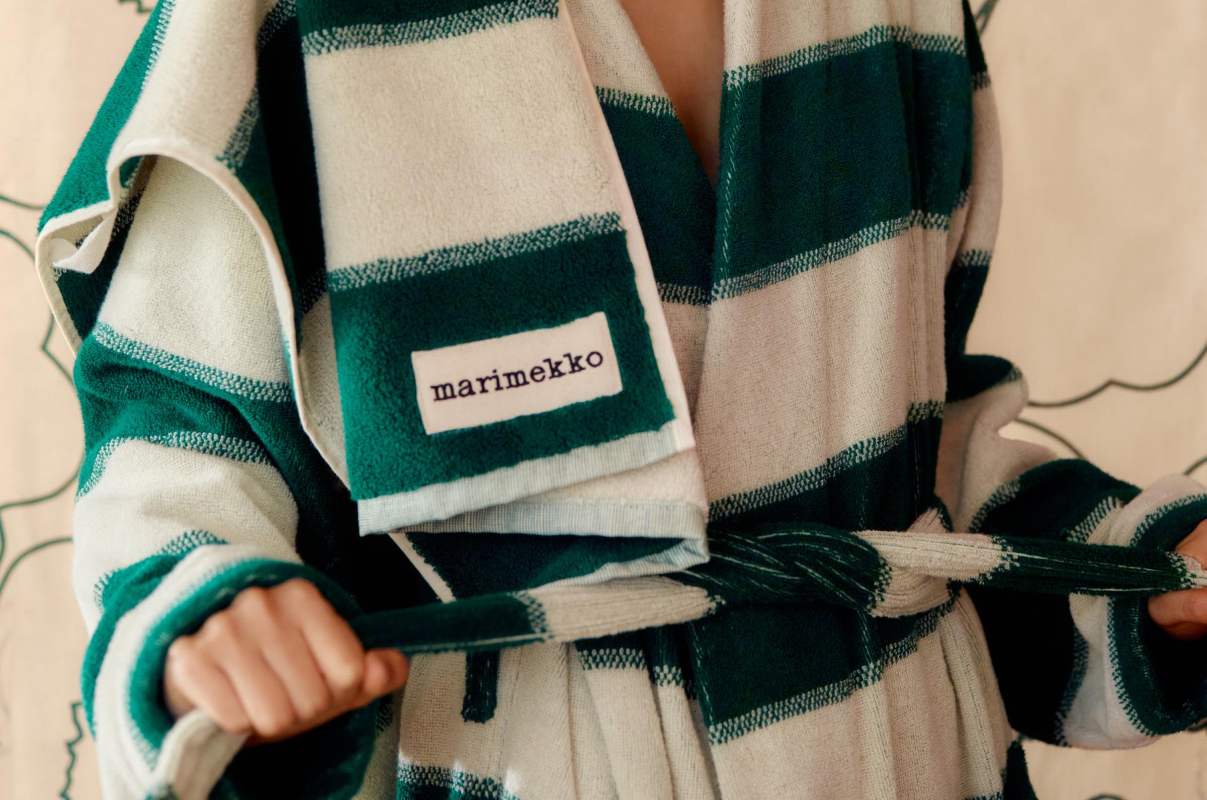 Model wearing a green and white Galleria-print terry bathrobe with a matching towel over her shoulder.