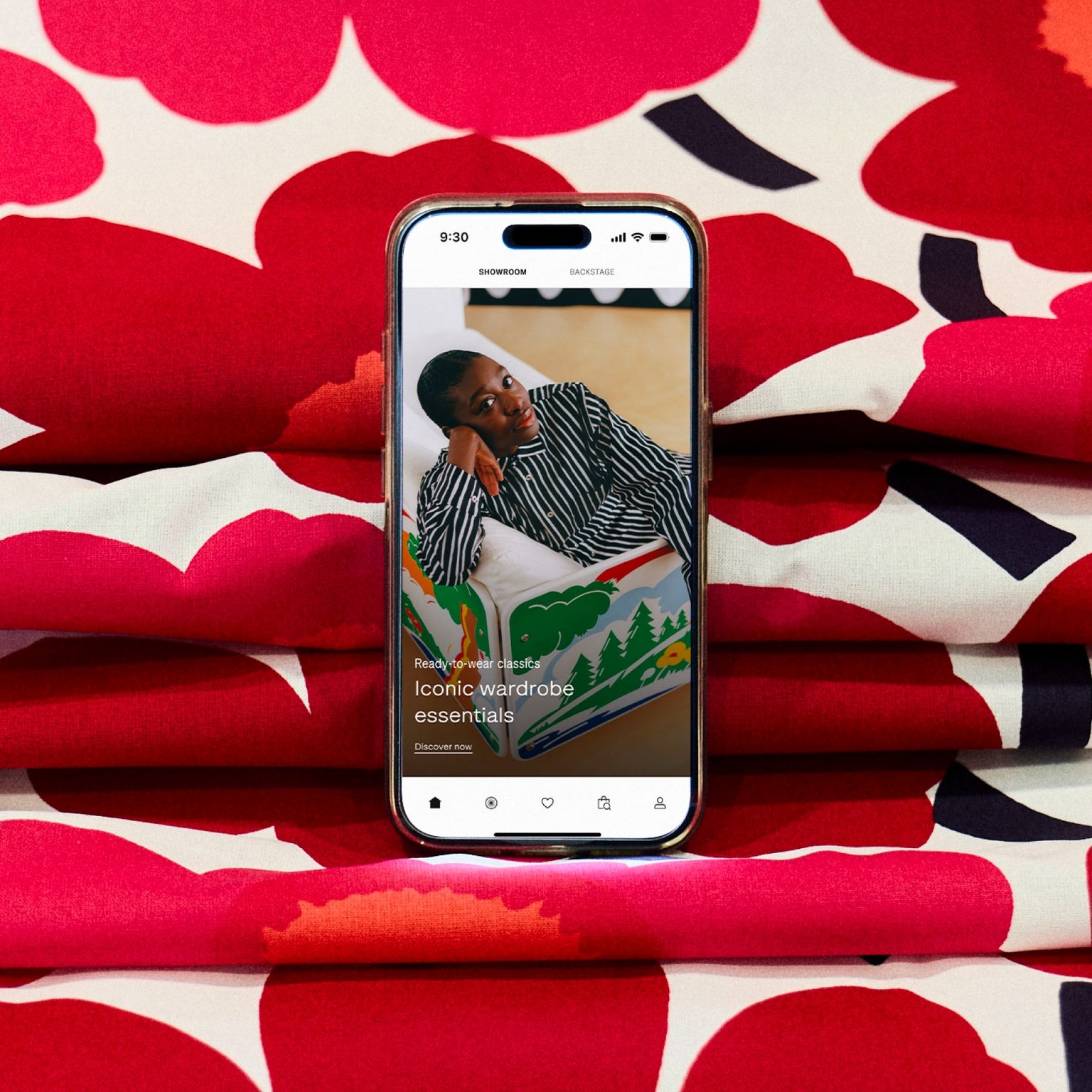 A phone with the Marimekko app open placed on Unikko fabric.