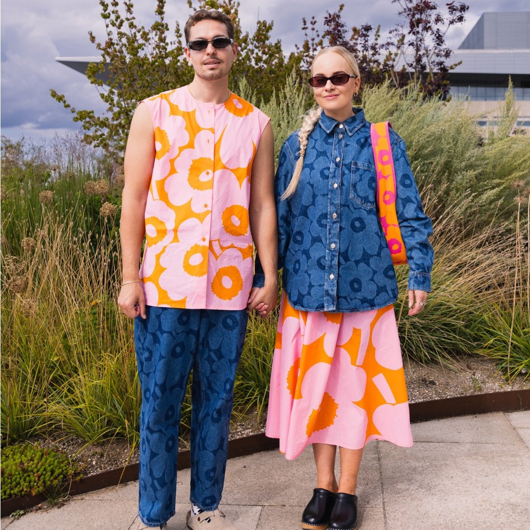 Miisa Grekov and Tomas Grekov in the matching outfits featuring Maridenim shirt and jeans plus pink-orange shirt and skirt with Unikko pattern.