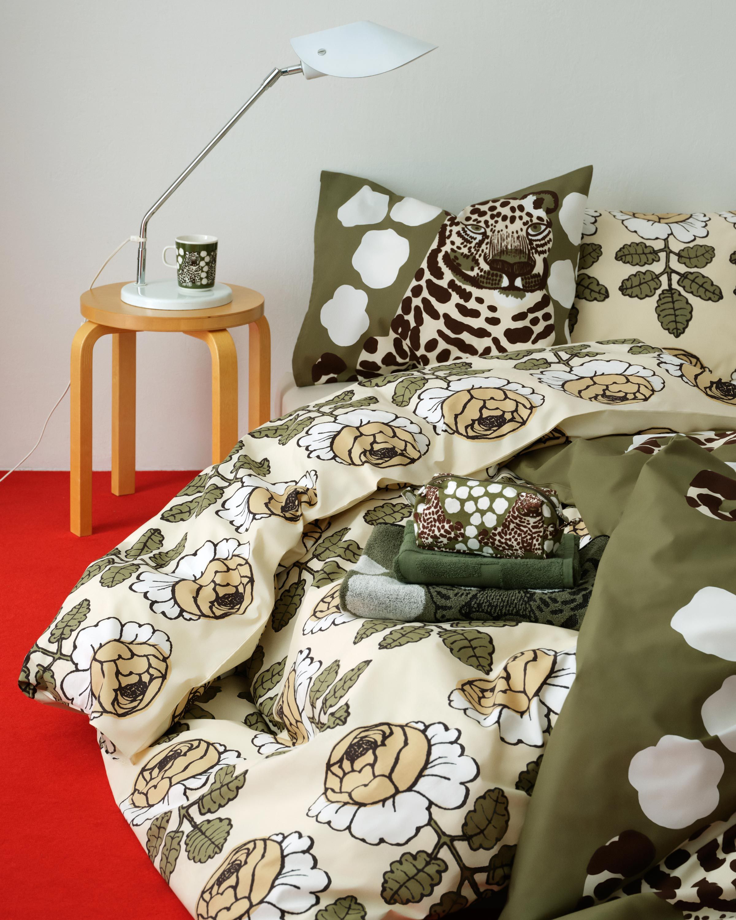 The bed linen on the bed has a Kaksoset pattern and a Maalaisruusu pattern. 
