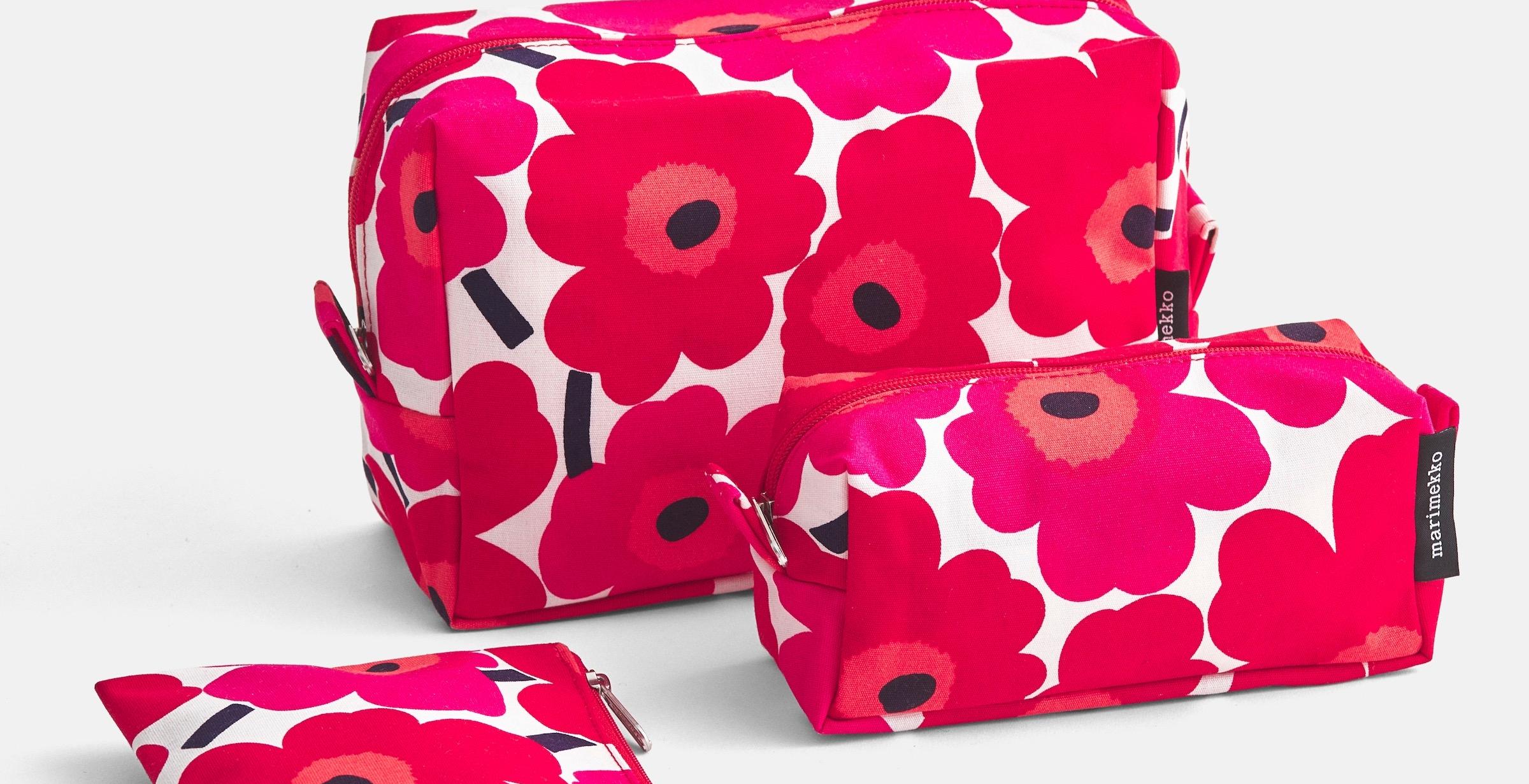 Red and white colored Unikko cosmetic bags in three different sizes.