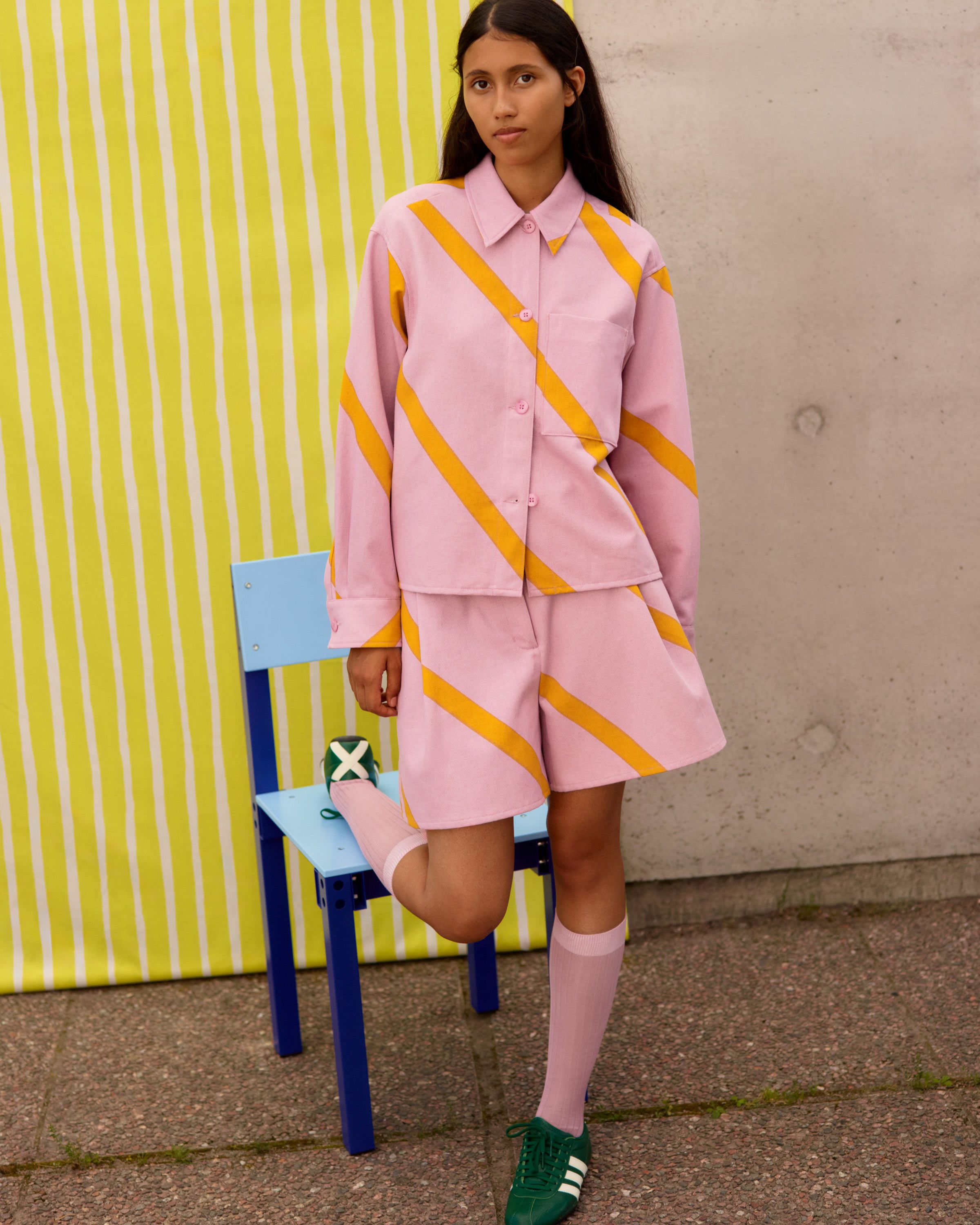 Malli, jolla on vaaleanpunainen Basso-painatuksella varustettu paita ja shortsit.