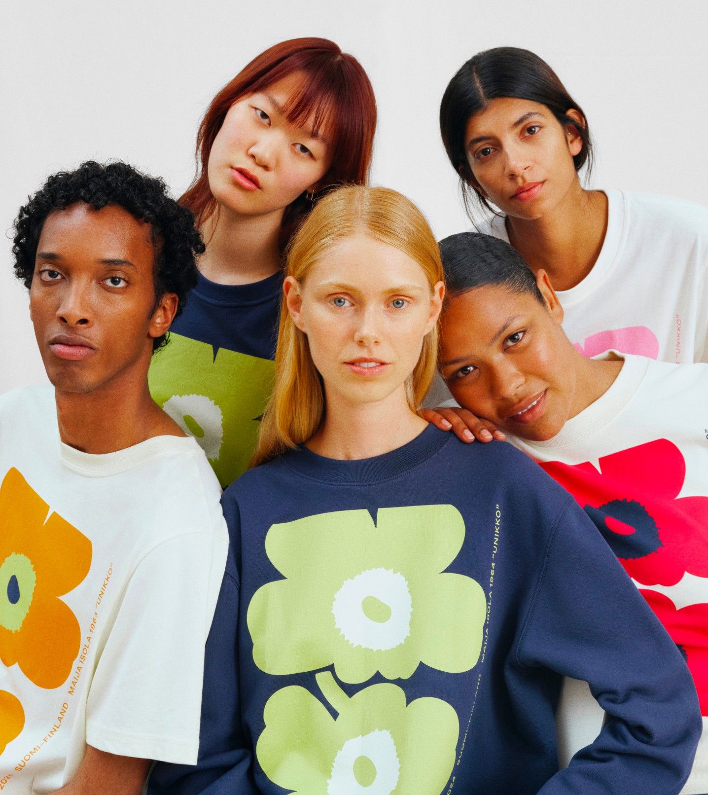 Models wearing colorful Unikko sweatshirts and T-shirts.