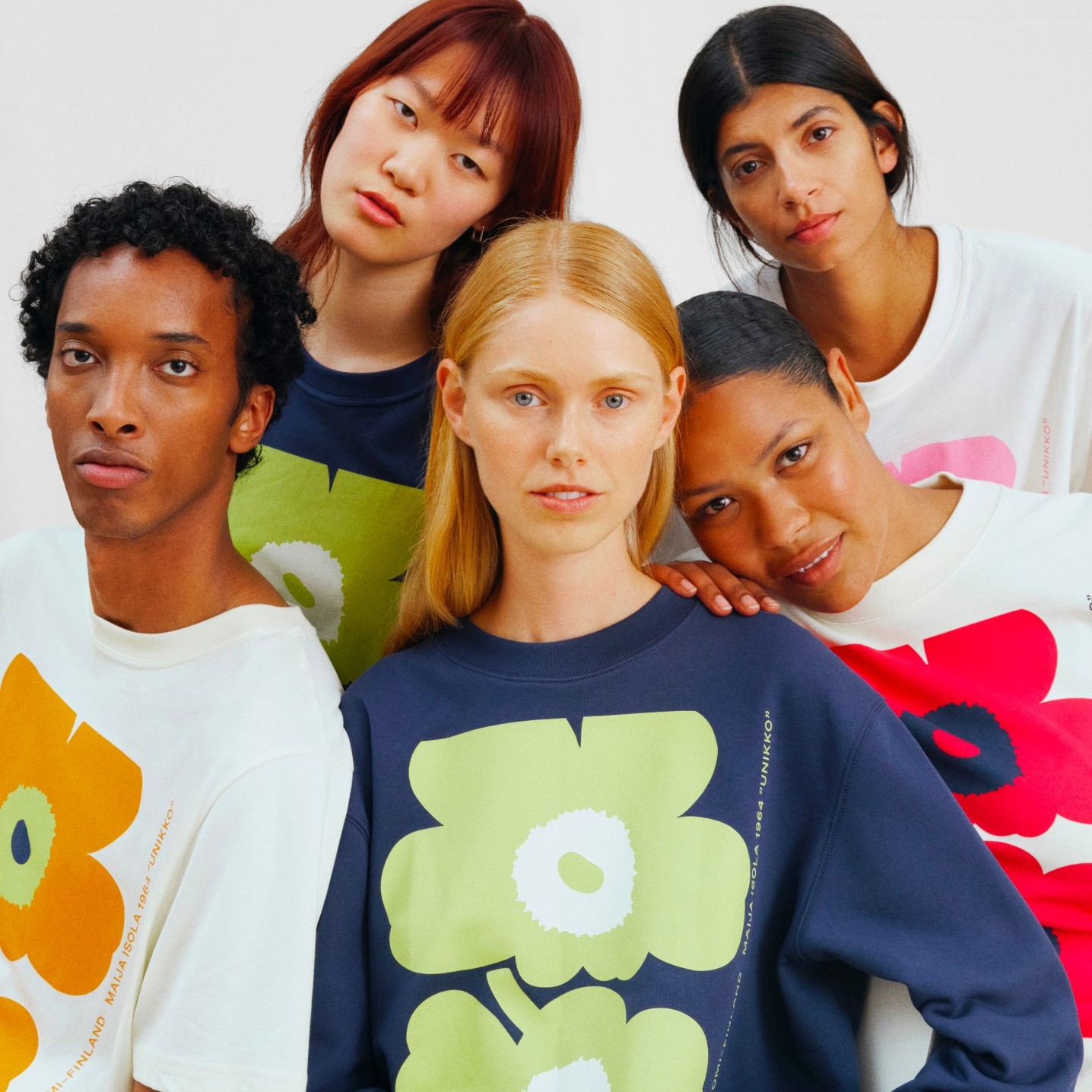 Modelle, die farbenfrohe Unikko-Sweatshirts und -T-Shirts tragen.