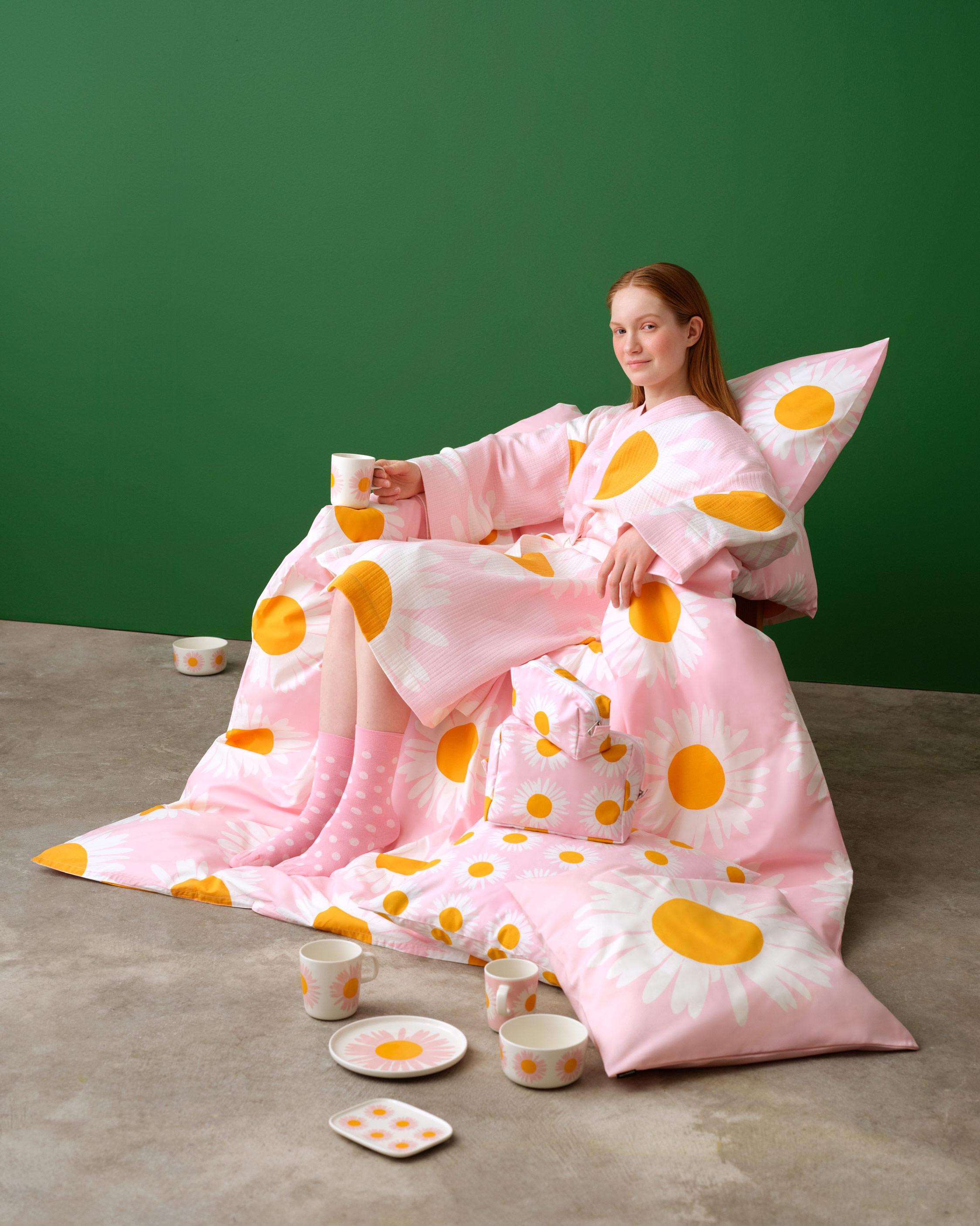 Mallin päällä Auringonkukka kylpytakki, hän istuu Auringonkukka astioiden ja bedding.