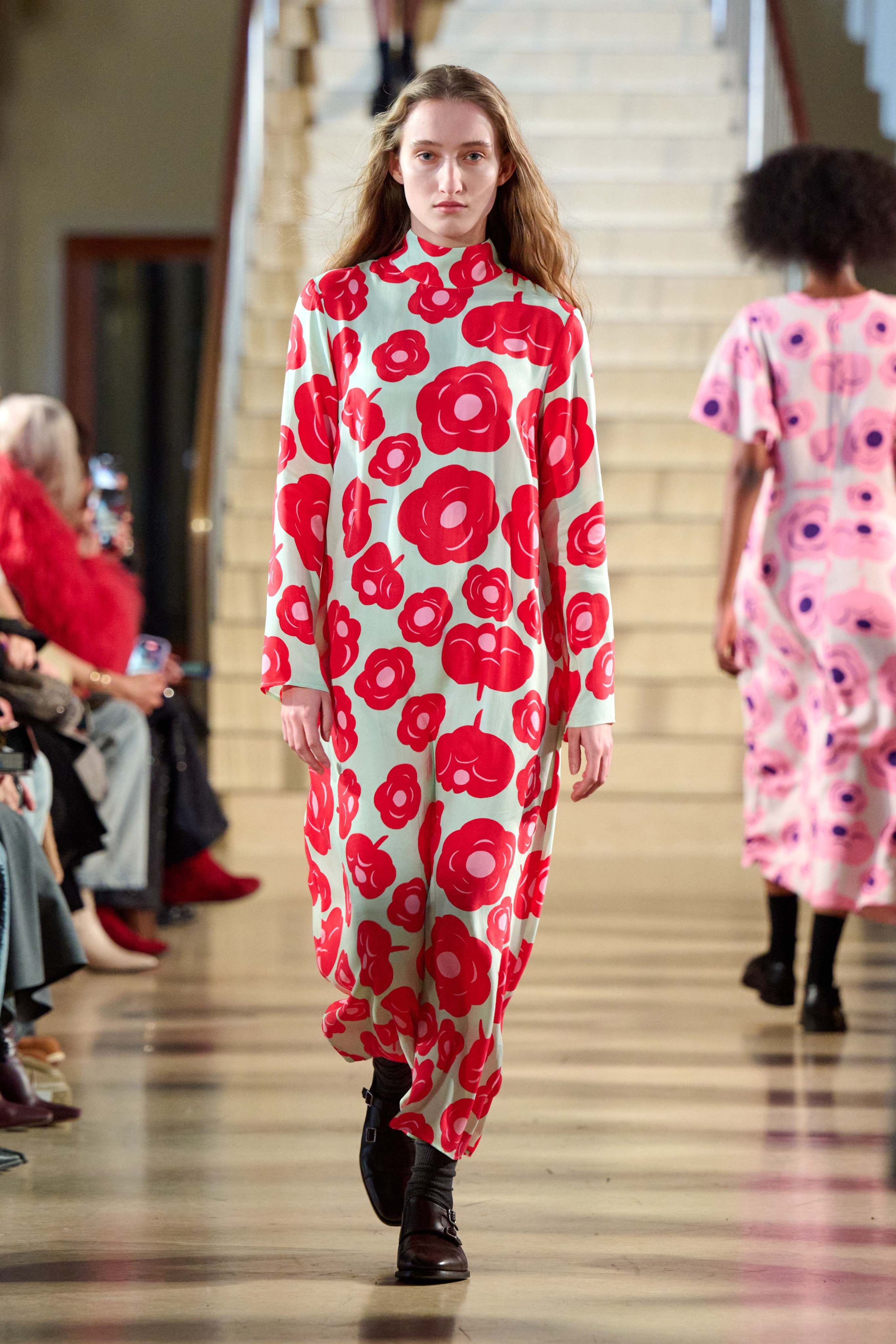 A model walking in Marimekko's fashion show wearing red dress