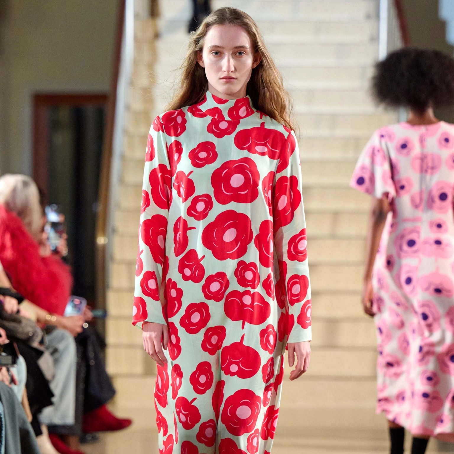 A model walking in Marimekko's fashion show wearing red dress