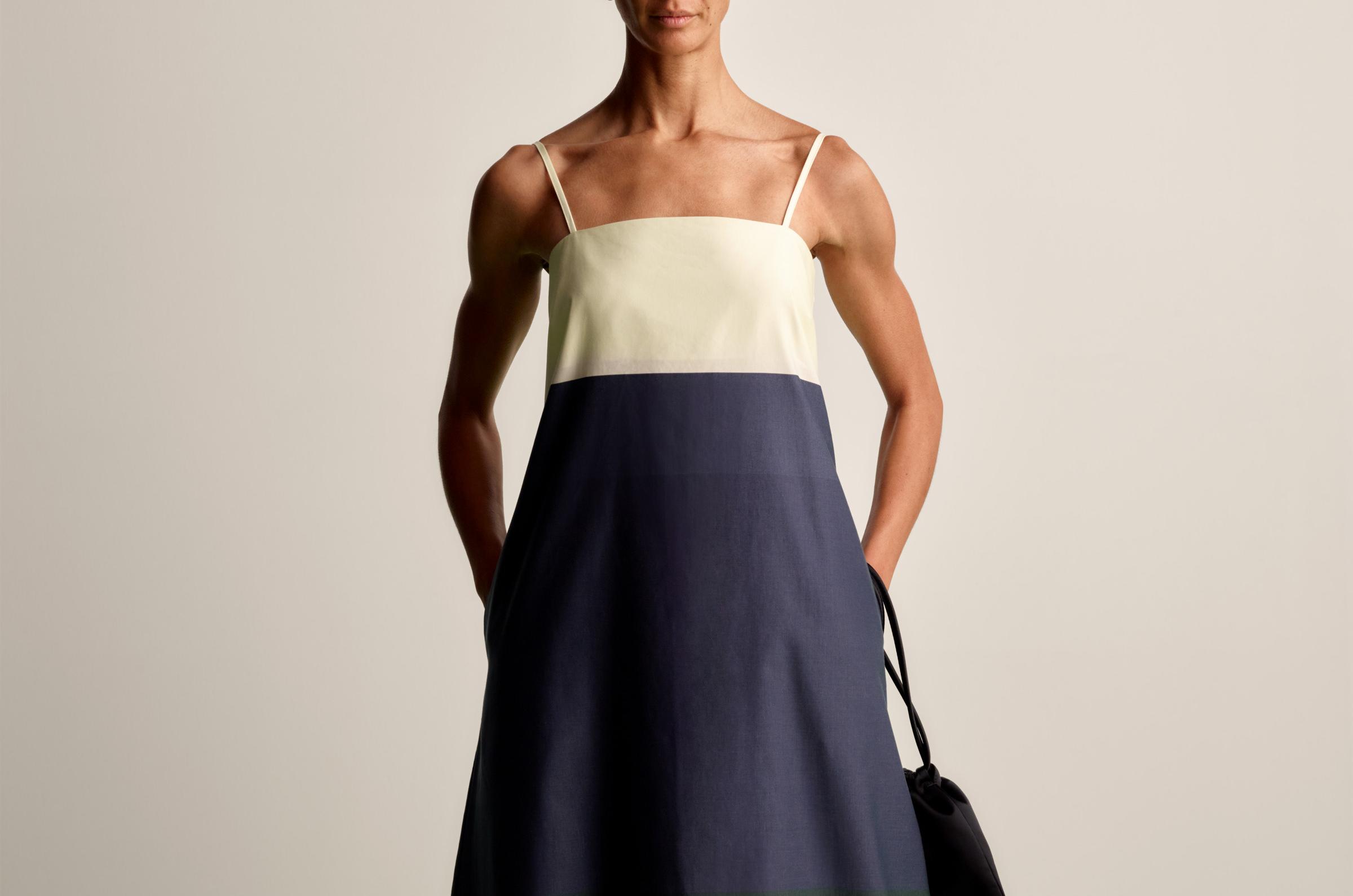Model wearing a sleeveless long dress in white, dark blue and green Hennika print.