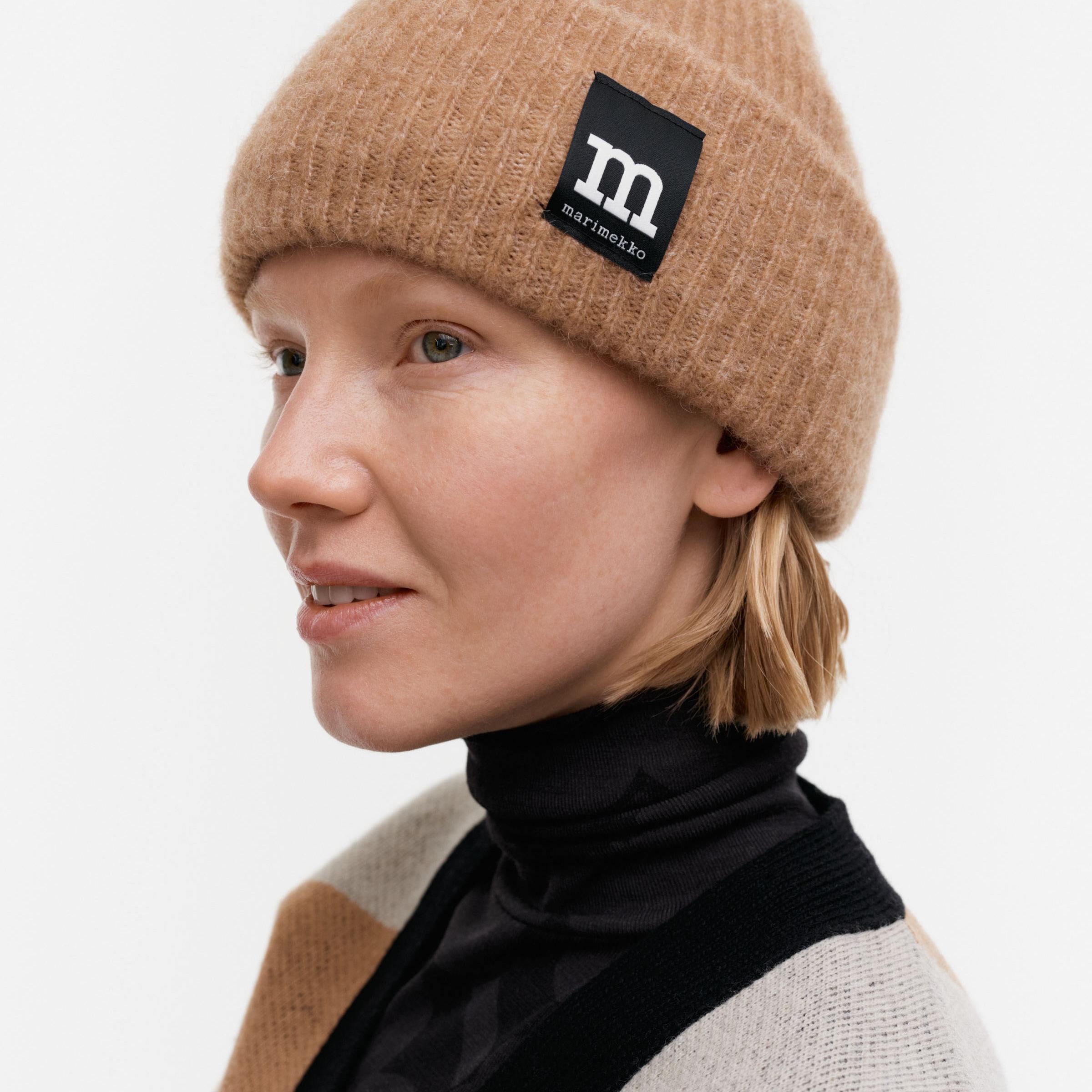 Model wearing beige Pjettar beanie.