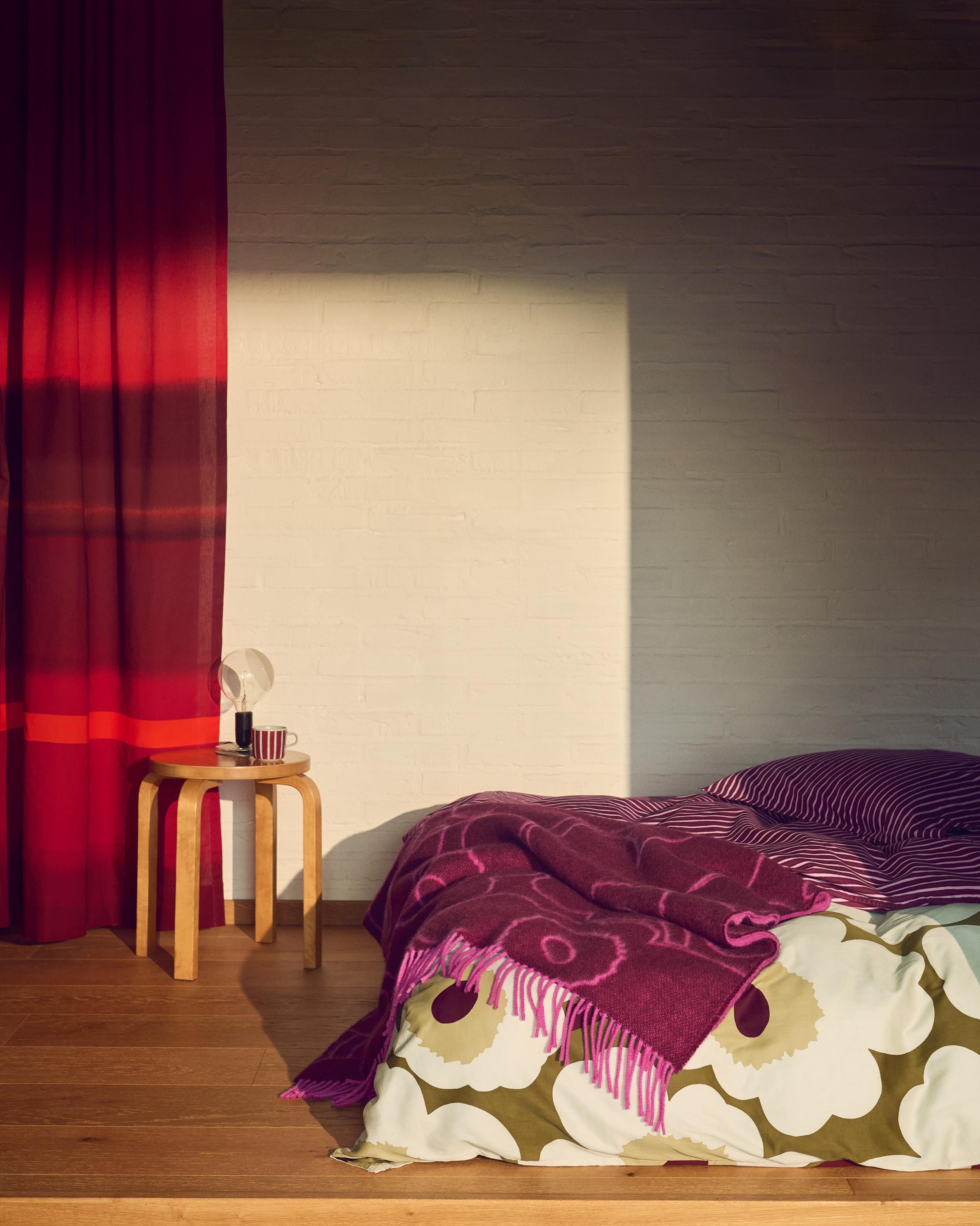 Vuodevaatteet ja huopa Unikko-kuviolla.