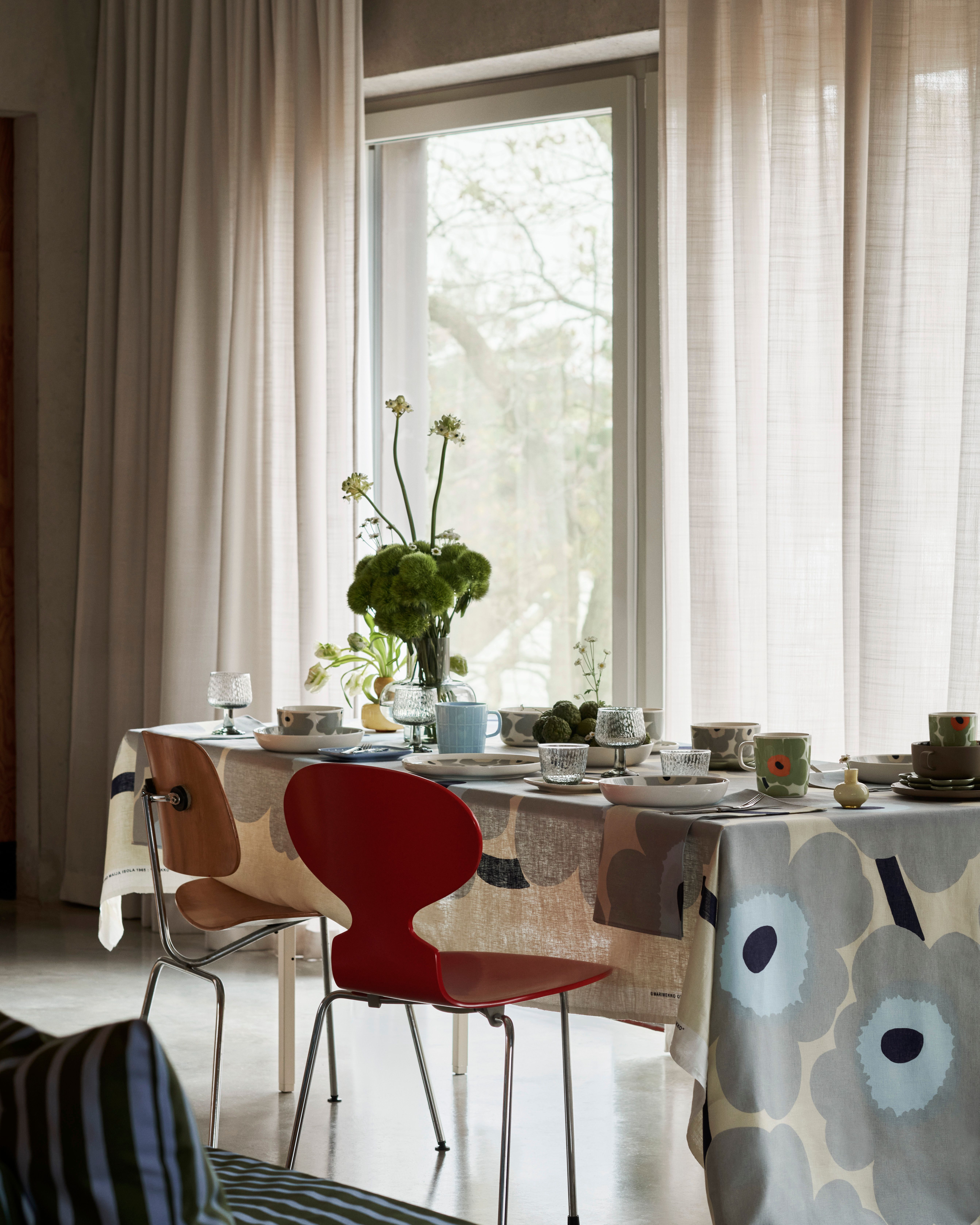 Ruokapöytän kattaus pöytäliinalla, joka on tehty Unikko kuviollisesta kankaasta