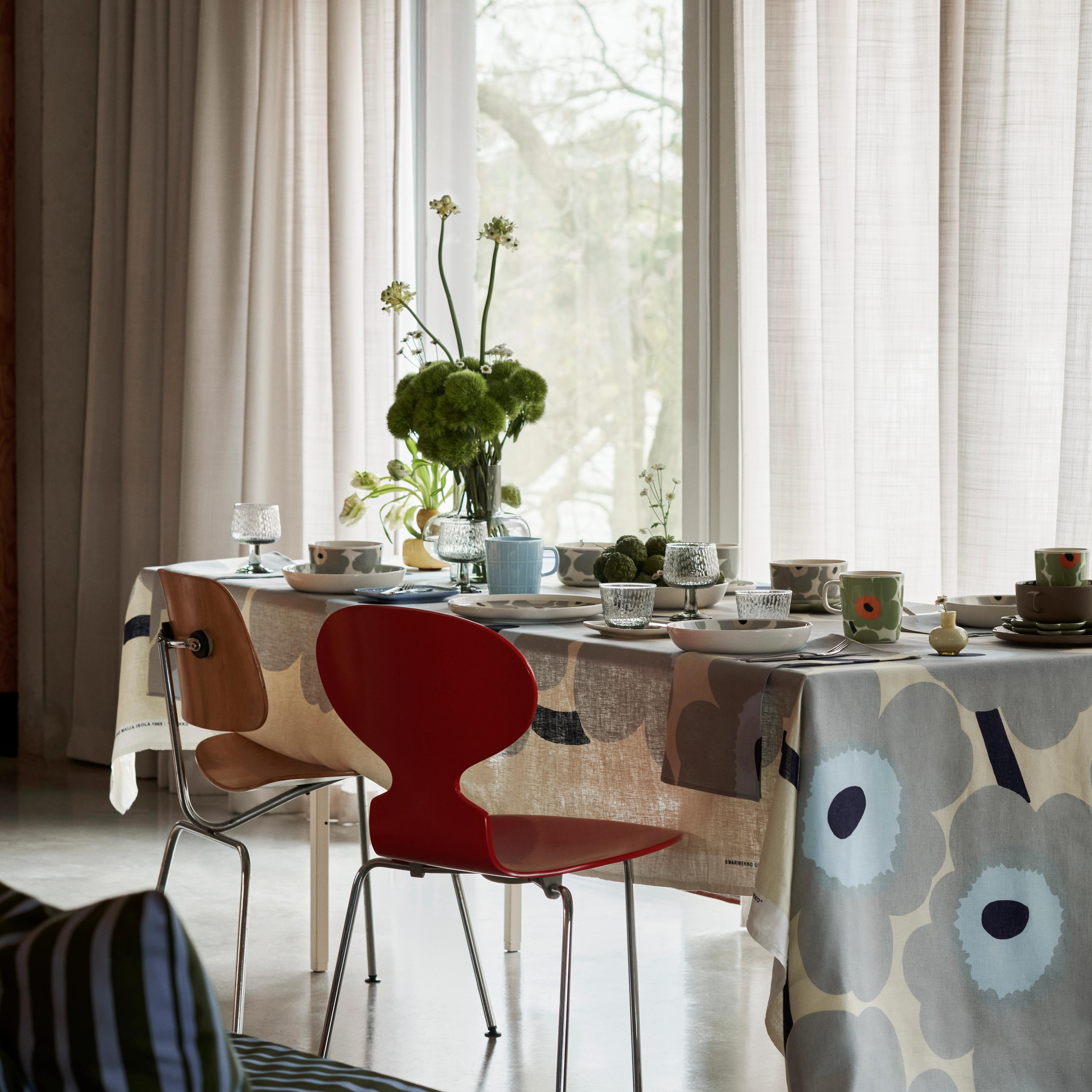 Ruokapöytän kattaus pöytäliinalla, joka on tehty Unikko kuviollisesta kankaasta