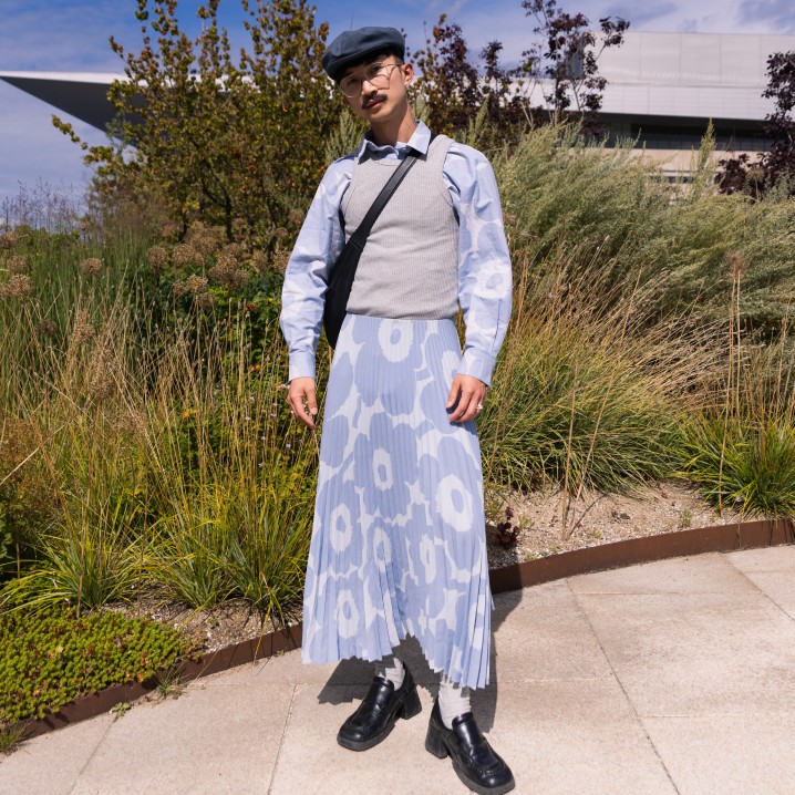 A guest at the fashion show wears a light blue Unikko patterned shirt and skirt.