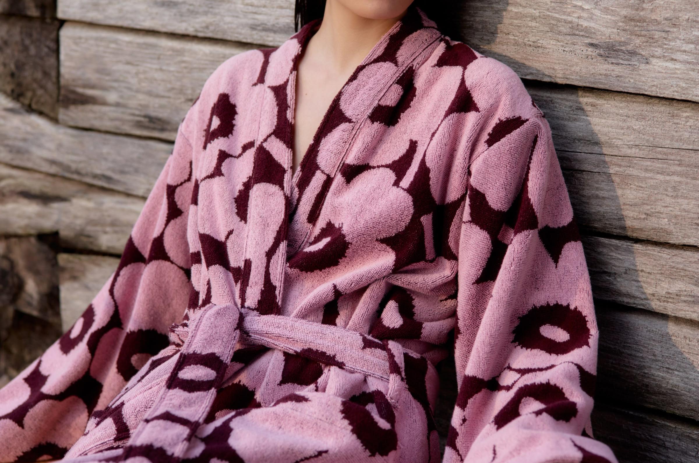 Model wearing a red and pink Unikko-print bathrobe outside.