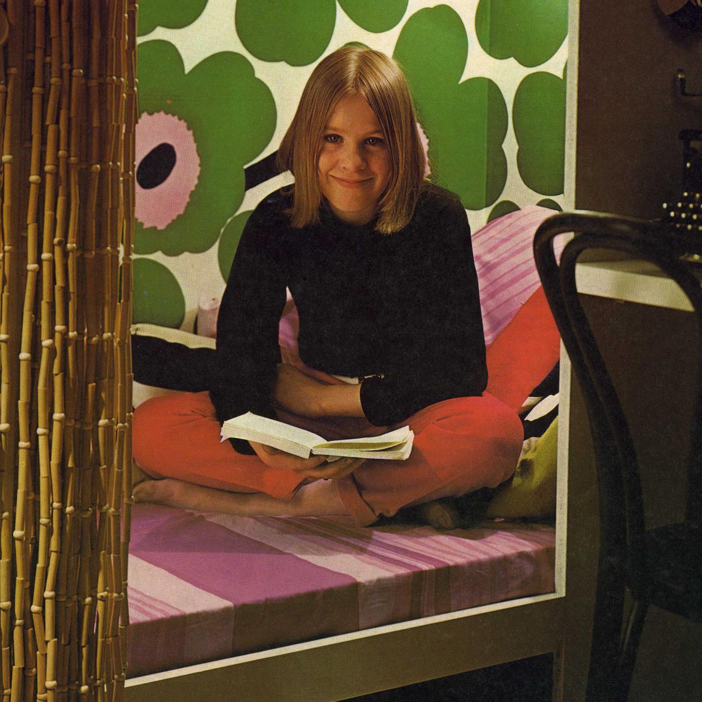 A young Maija Isola reading a book.