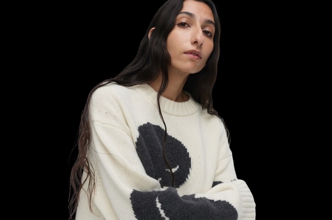 Malli yllään Luonto Tumma -neule mustalla taustalla.