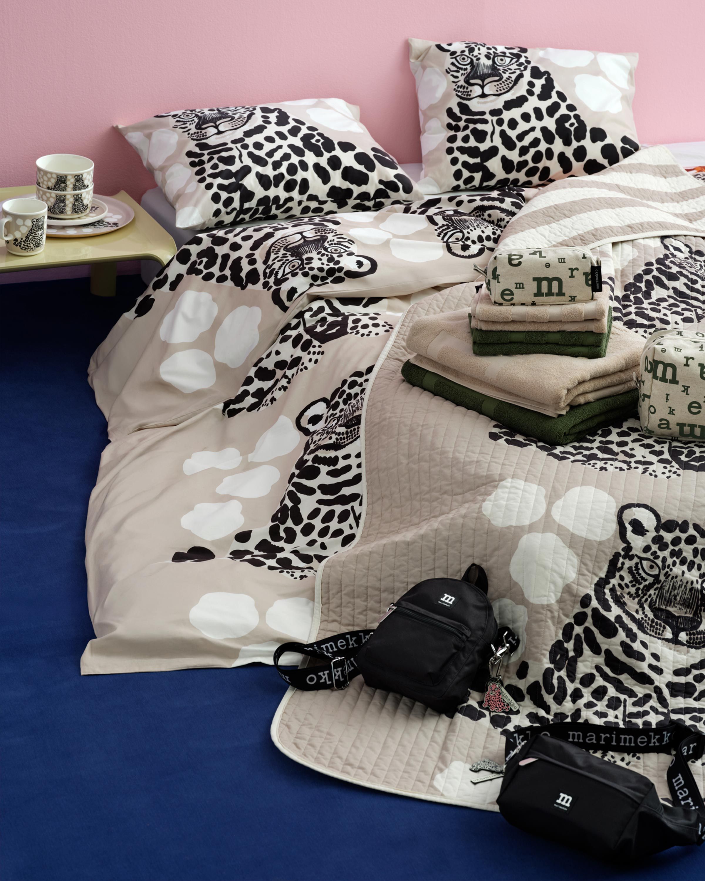 Beige Kaksoset bedding placed on a bed.