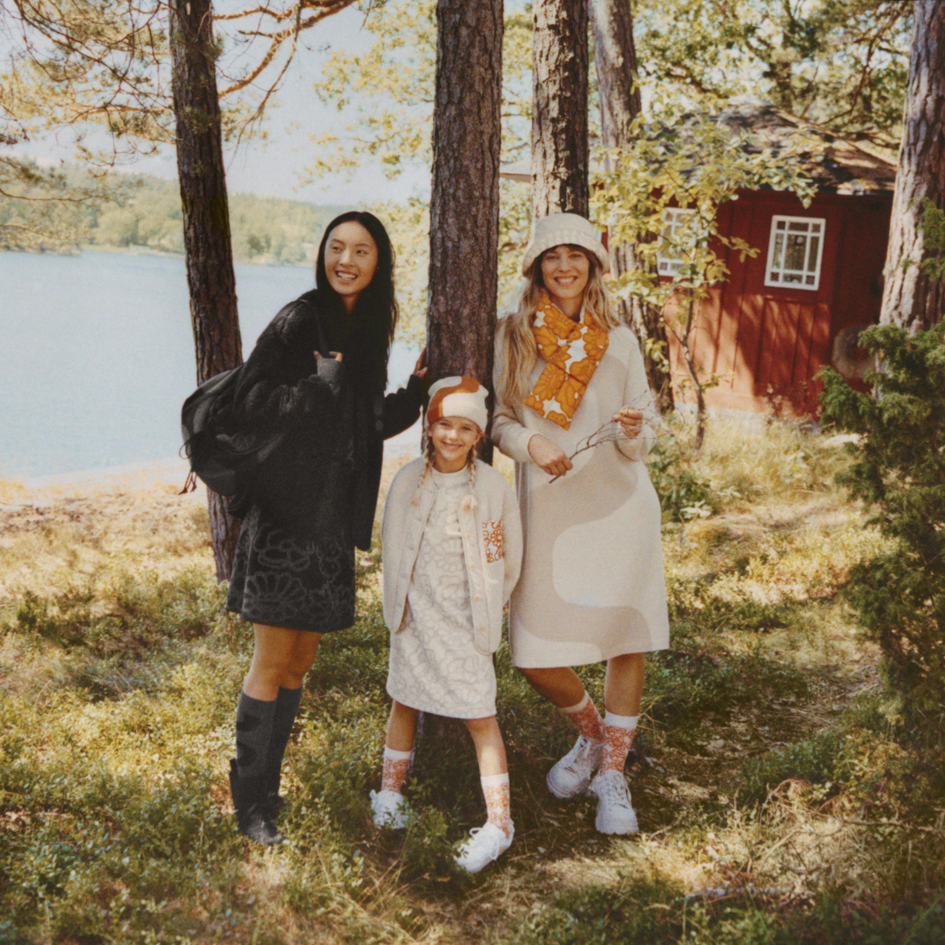 Zwei Erwachsene und ein Kind tragen Kleidung aus der Marimekko & Uniqlo-Kooperation