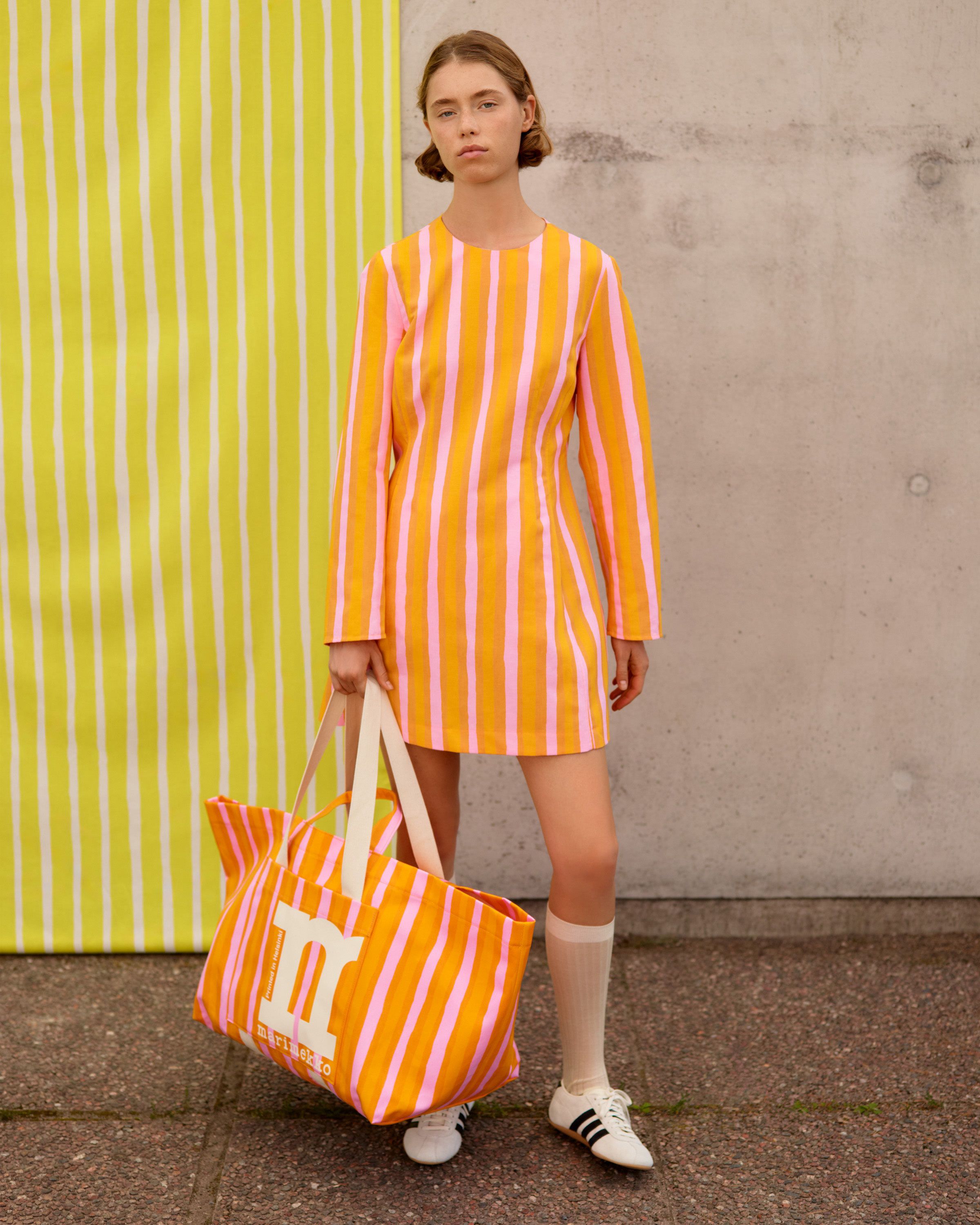 Model wearing a dress in orange Piccolo print.