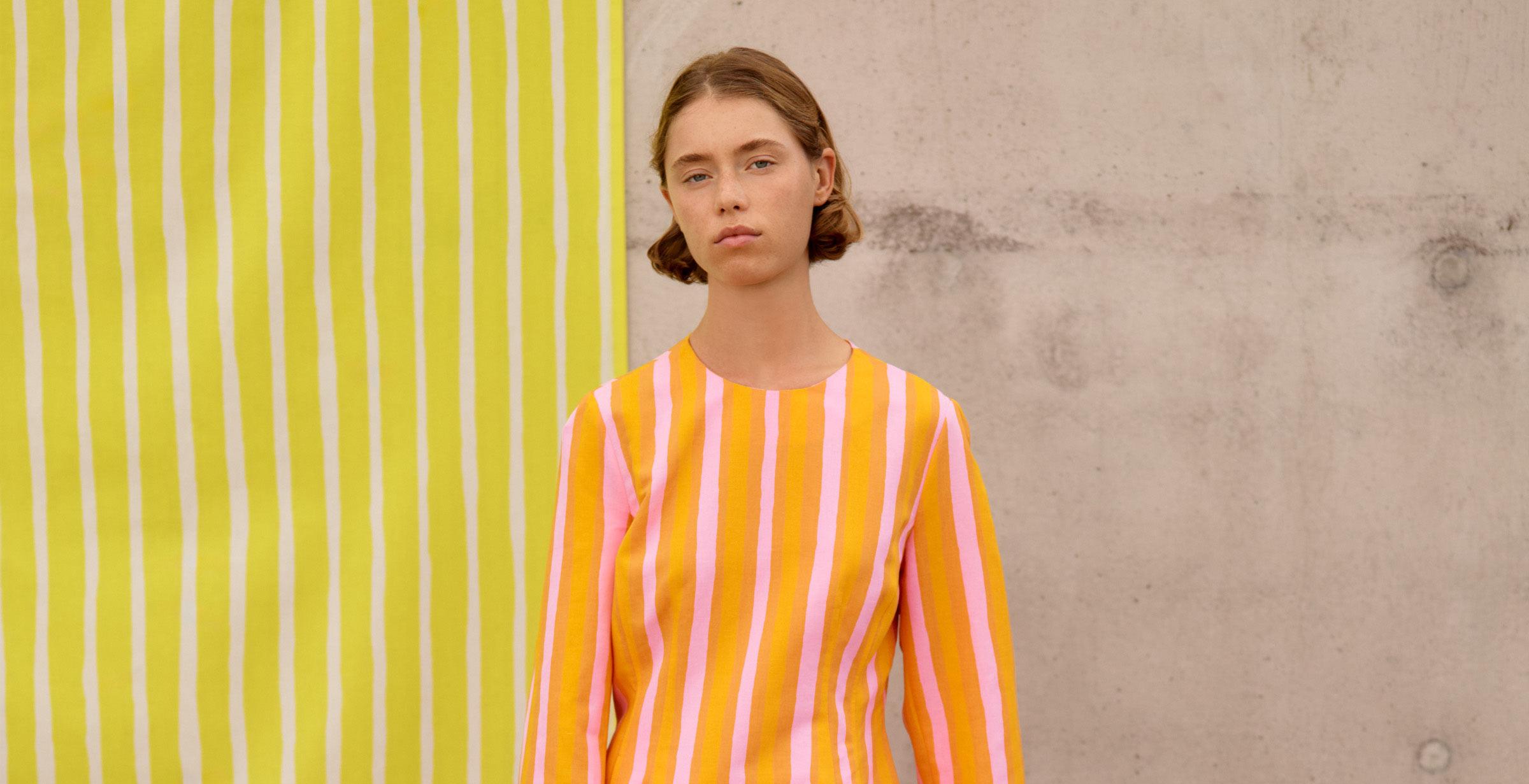 Model wearing a dress in orange Piccolo print.