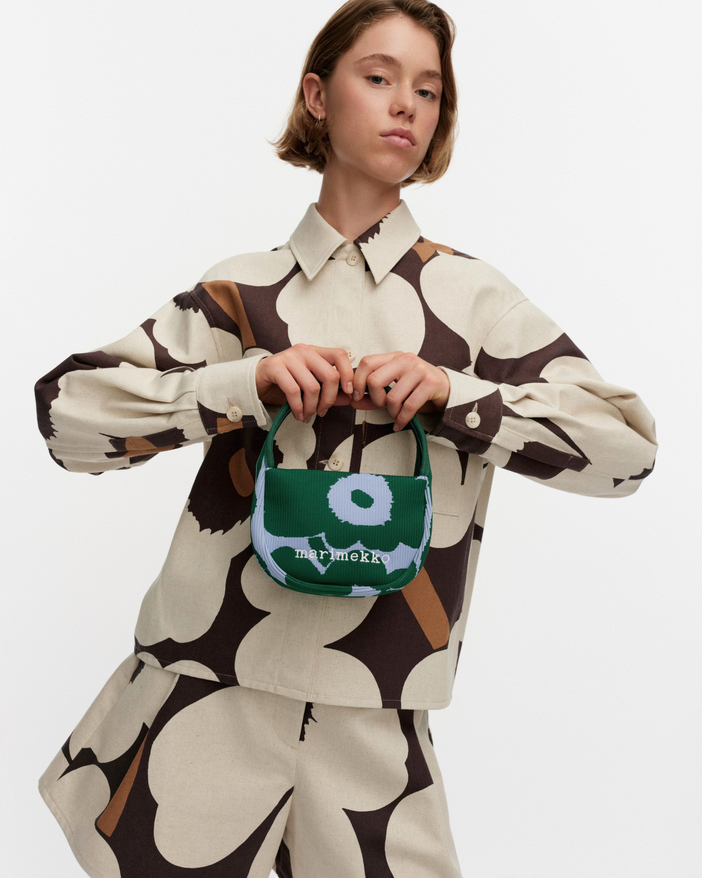 Model holding a Knitted mini handbag in Unikko print.