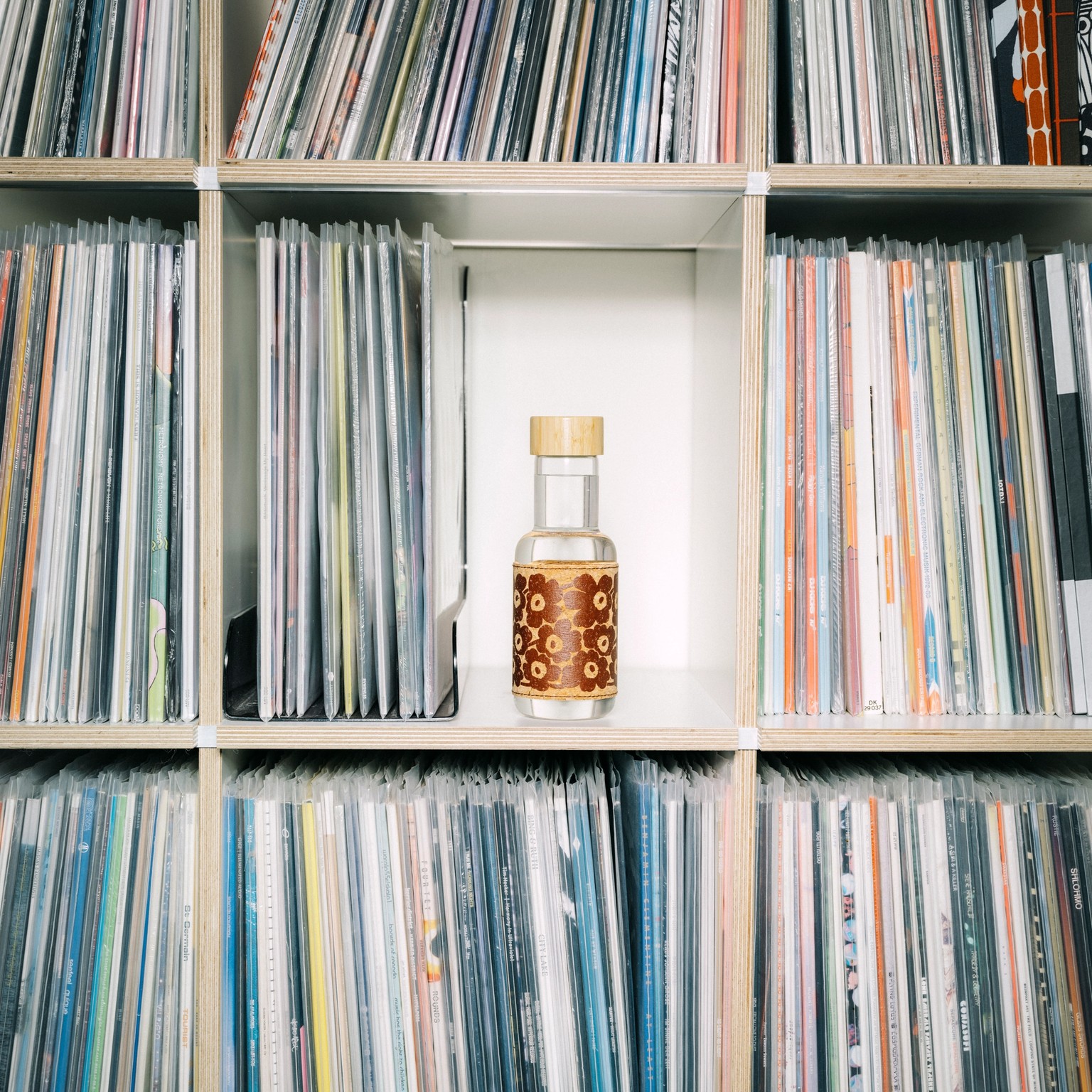 Marimade bottle placed on a bookshelf between vinyl records.