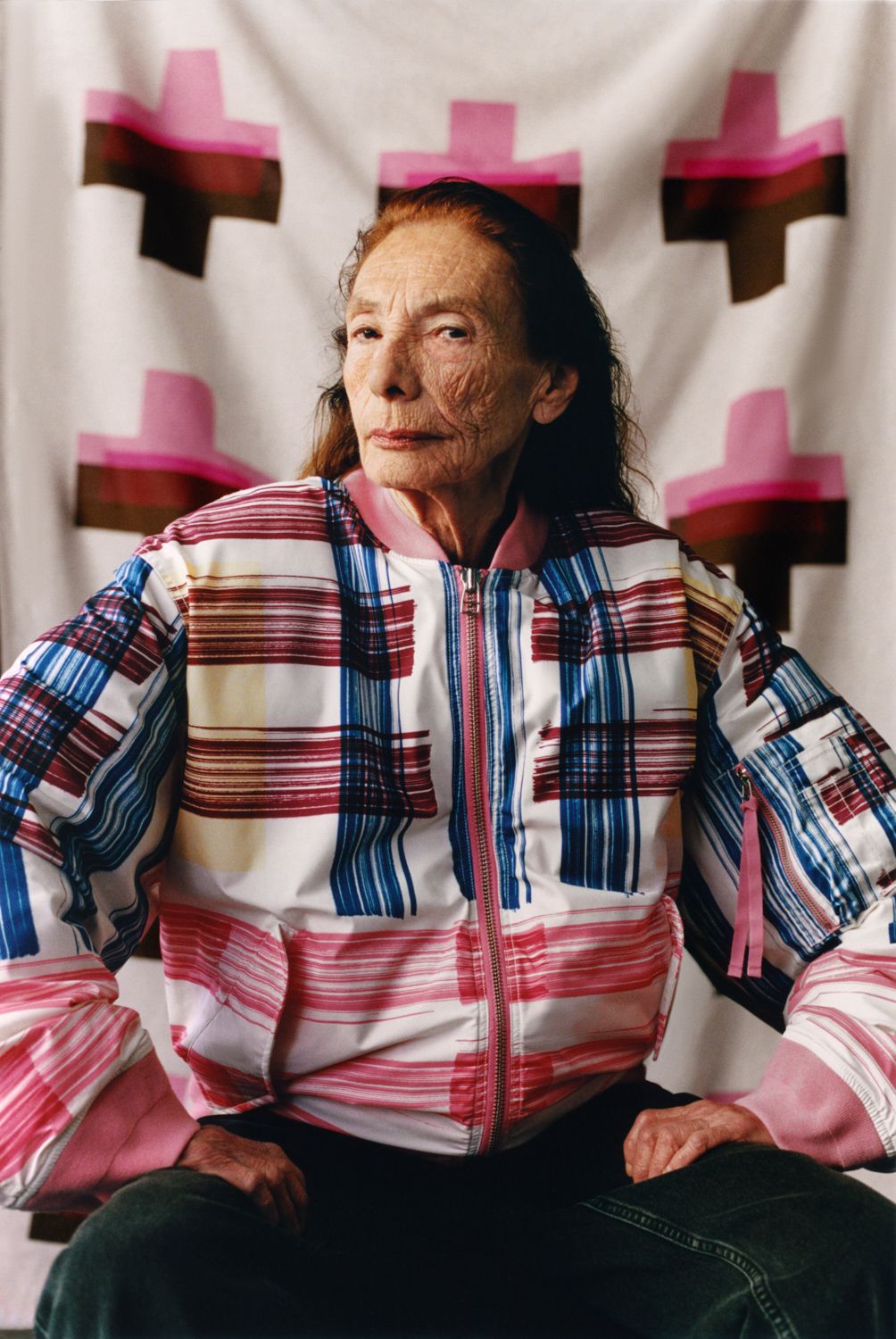 The model is sitting with the fabric as a background and is wearing a Mänty jacket.
