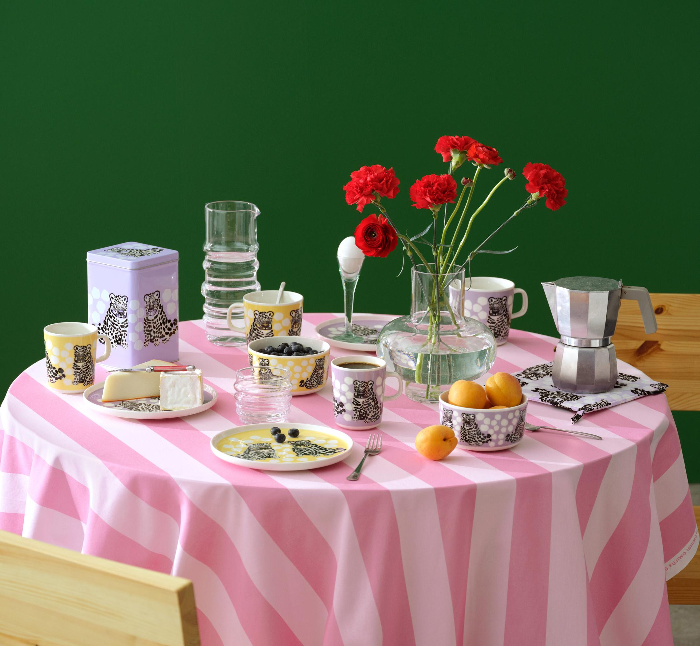 A table set with a Korsi table cloth in pink and Kaksoset tableware in yellow and purple
