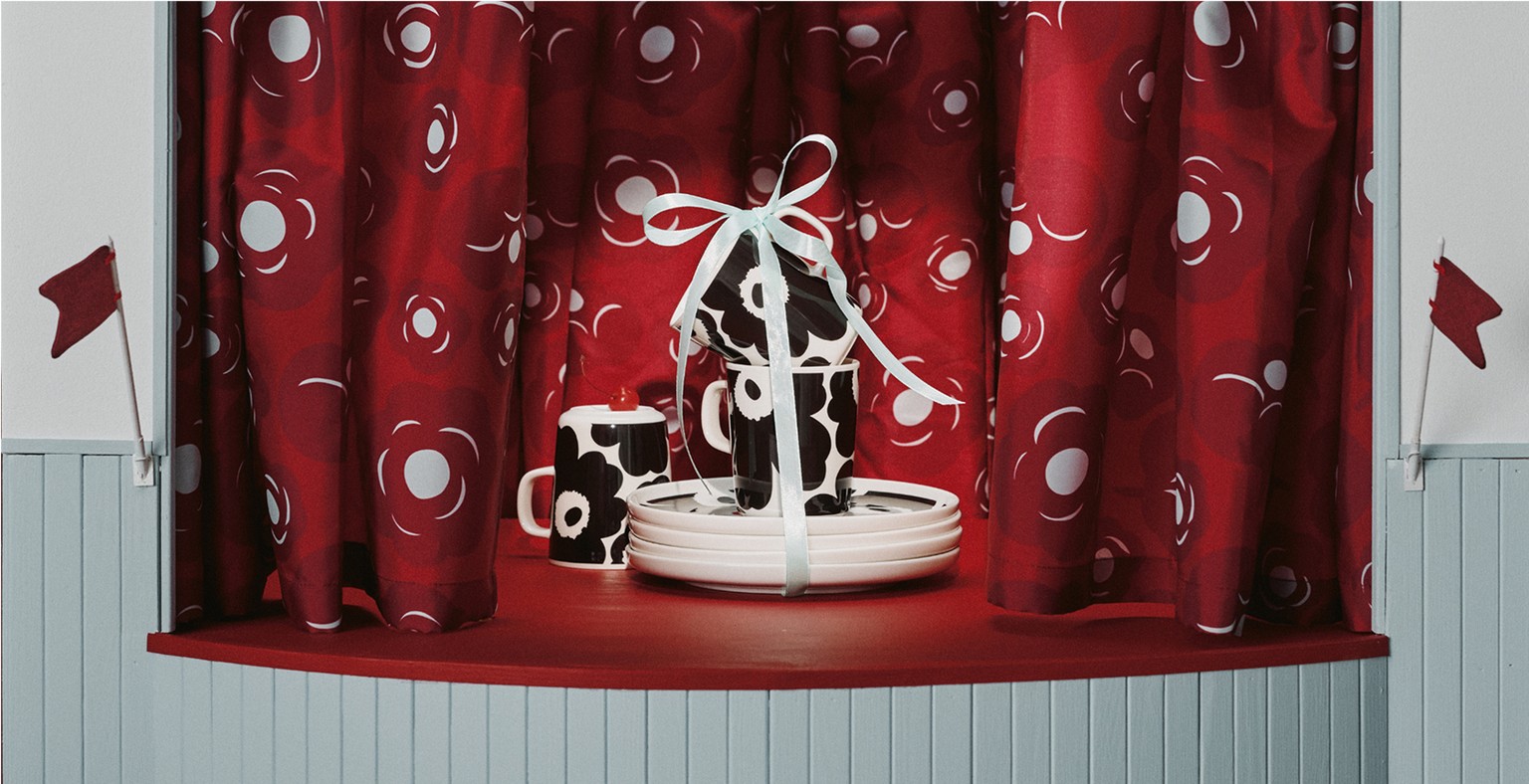 Unikko mug and plate set, wrapped with a bow, displayed on stage.