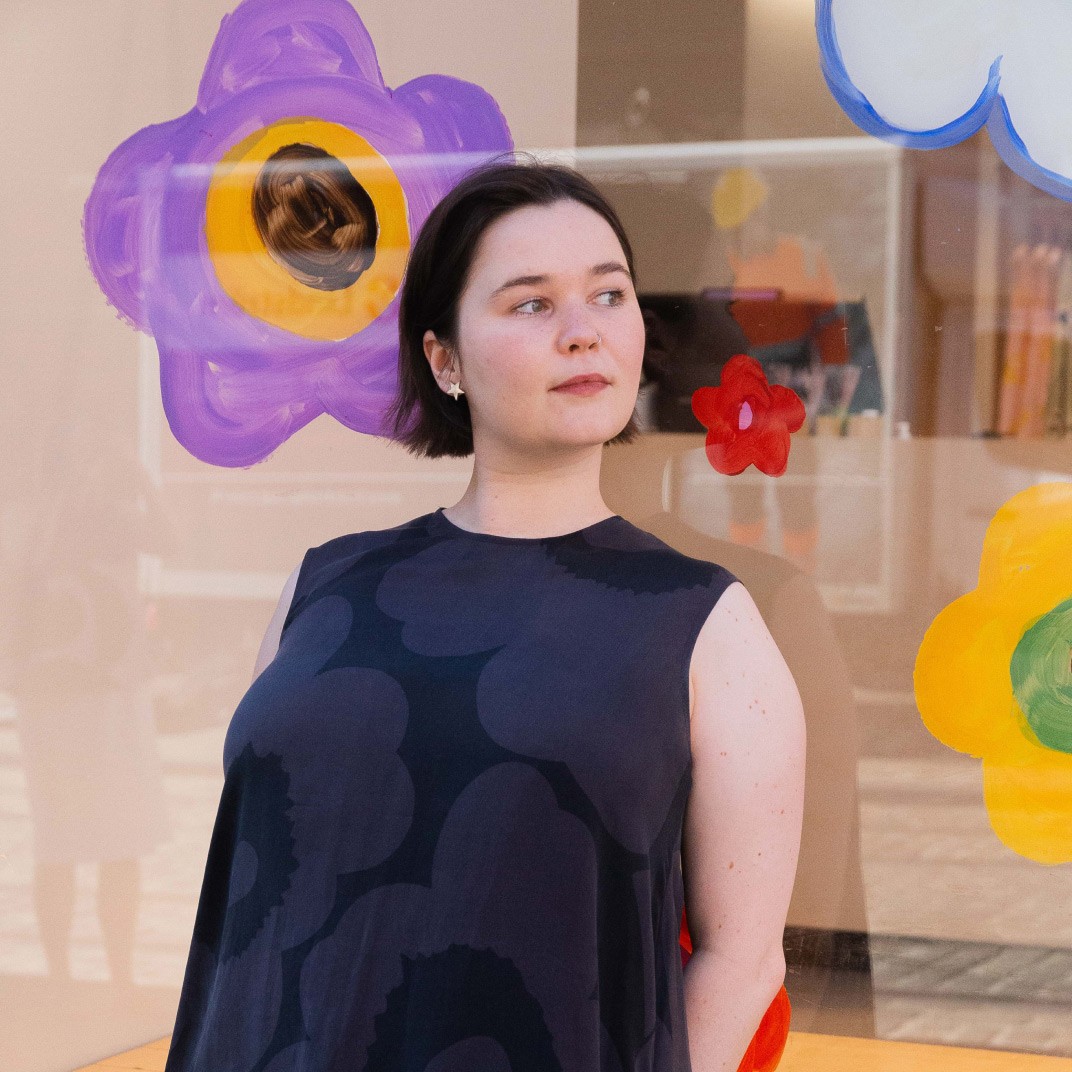 Emma Thomas poseeraamassa luomansa Pride taideikkunan edessä