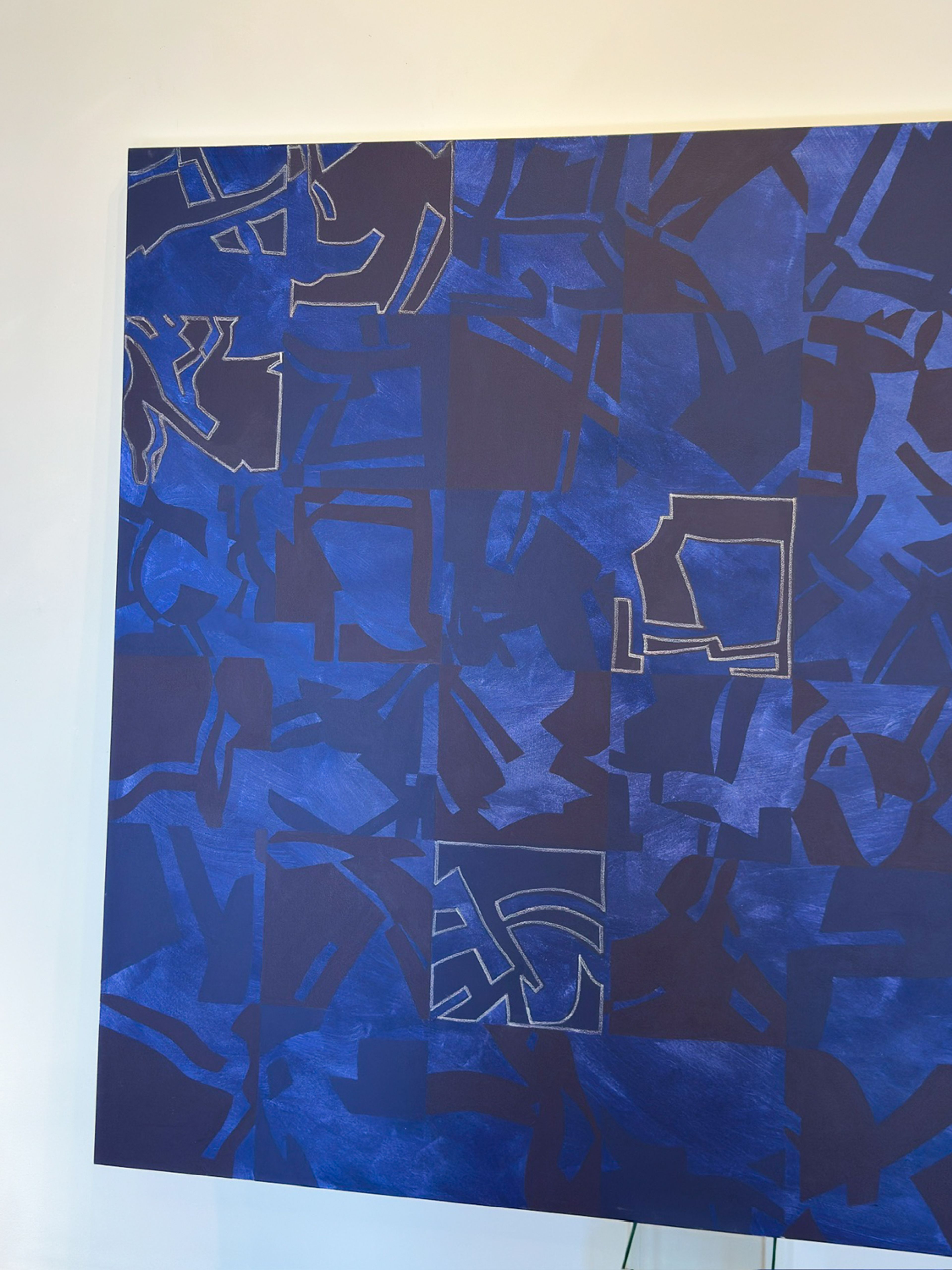 Abstract painting in various shades of blue and indigo, featuring a grid pattern with organic and geometric shapes, some outlined in white chalk.