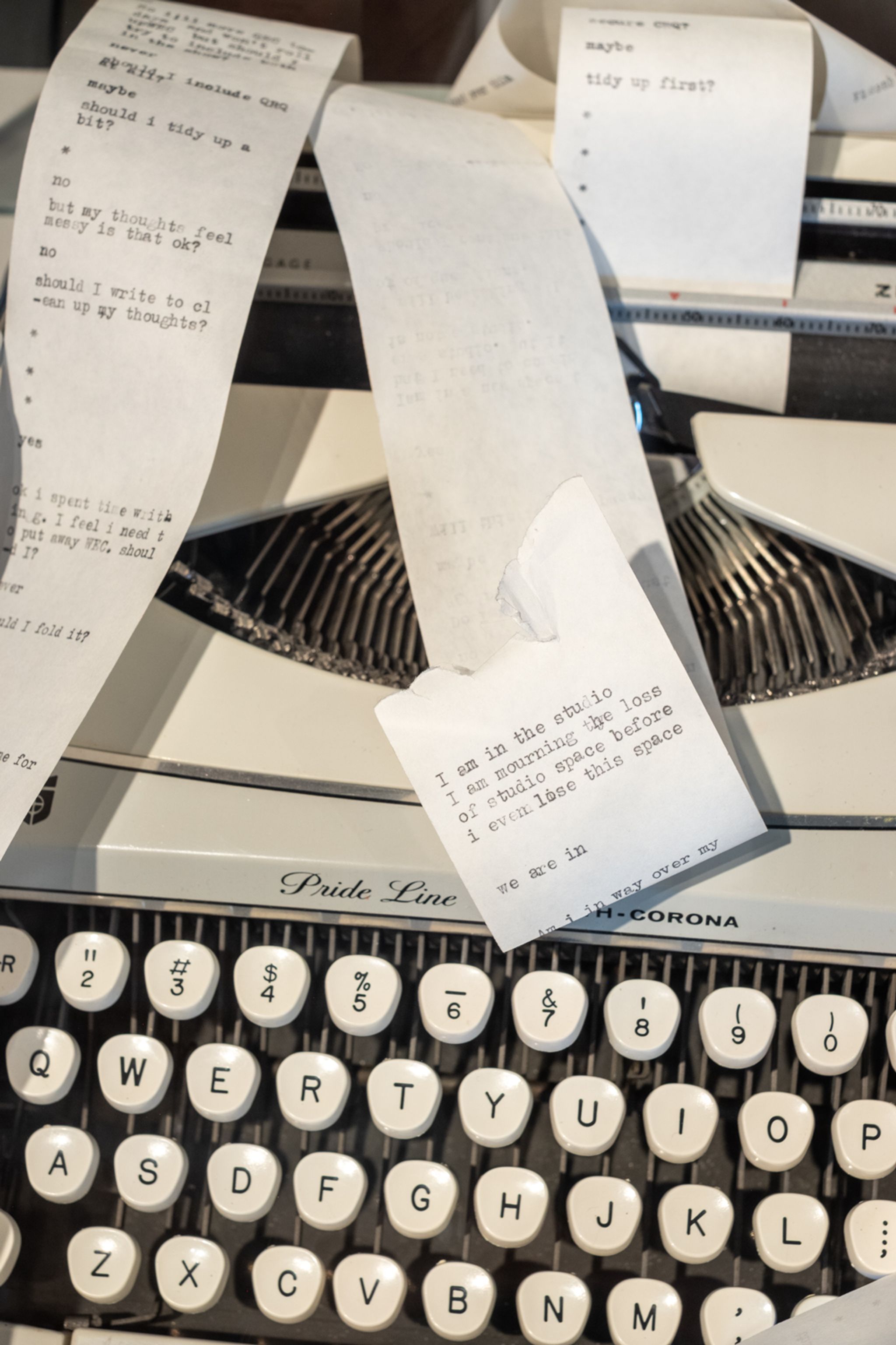 A vintage Smith-Corona typewriter with a continuous paper strip filled with typed questions and answers.