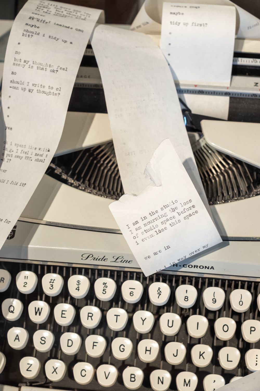 A vintage Smith-Corona typewriter with a continuous paper strip filled with typed questions and answers.