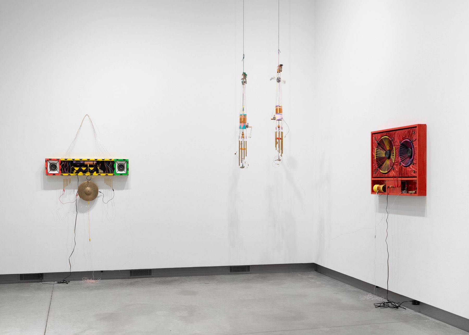 Peter Simensky, (left to right) Boombox - Honey Bee, 2023; wind chimes (pink + blue radio), 2021; wind chimes (pink, purple + yellow radio), 2021; Cabinet - Cherry Red, 2023.