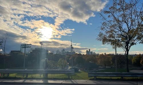 A view of the CN Tower and man admiring in the foreground.