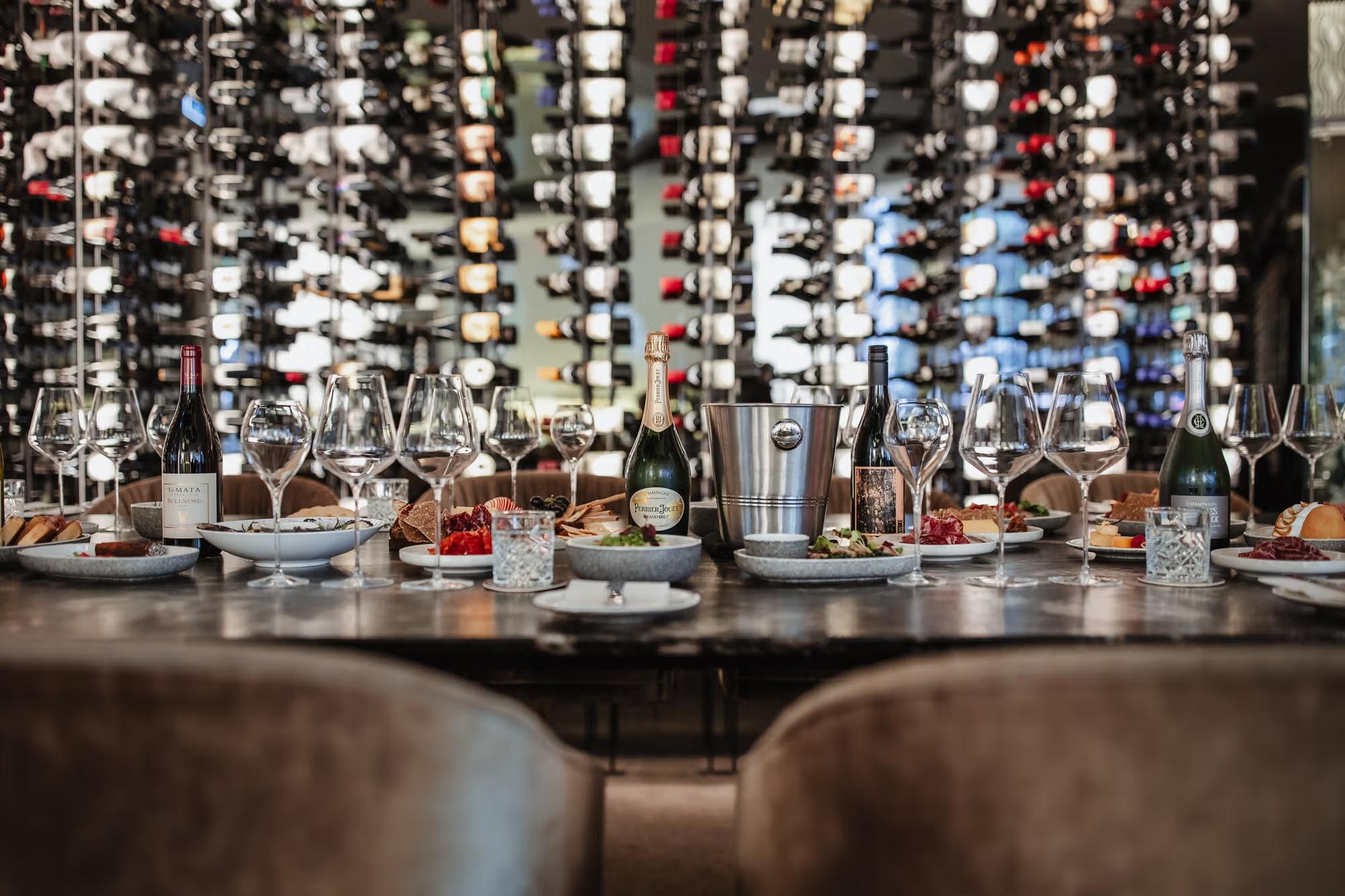 Table with wine bottles and various food dishes